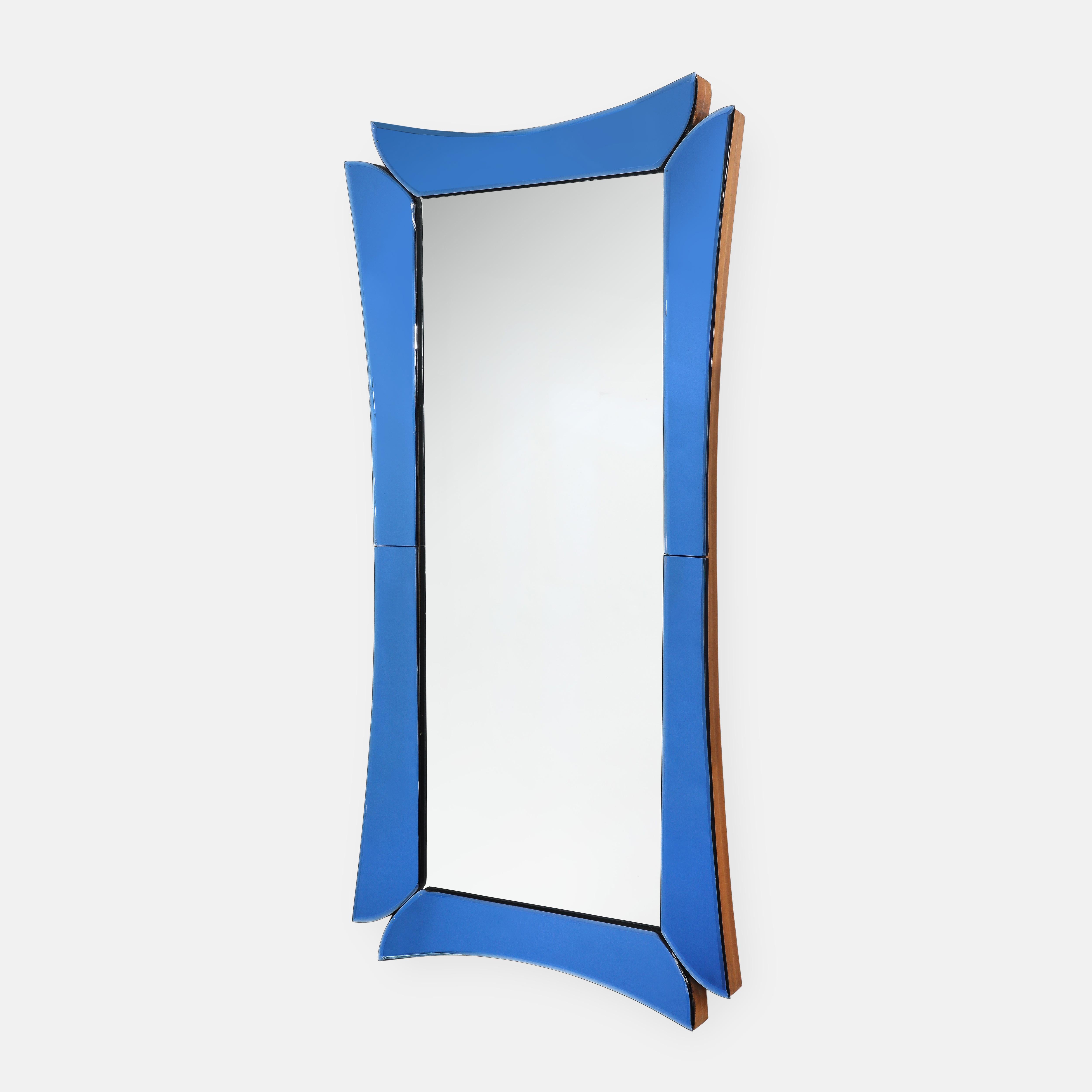 Cristal Art rare grand miroir rectangulaire avec cadre épais biseauté en verre de cristal bleu et découpes suspendant le verre central en miroir sur un support en bois, Italie, années 1950. Ce miroir chic et saisissant exsude le modernisme et la