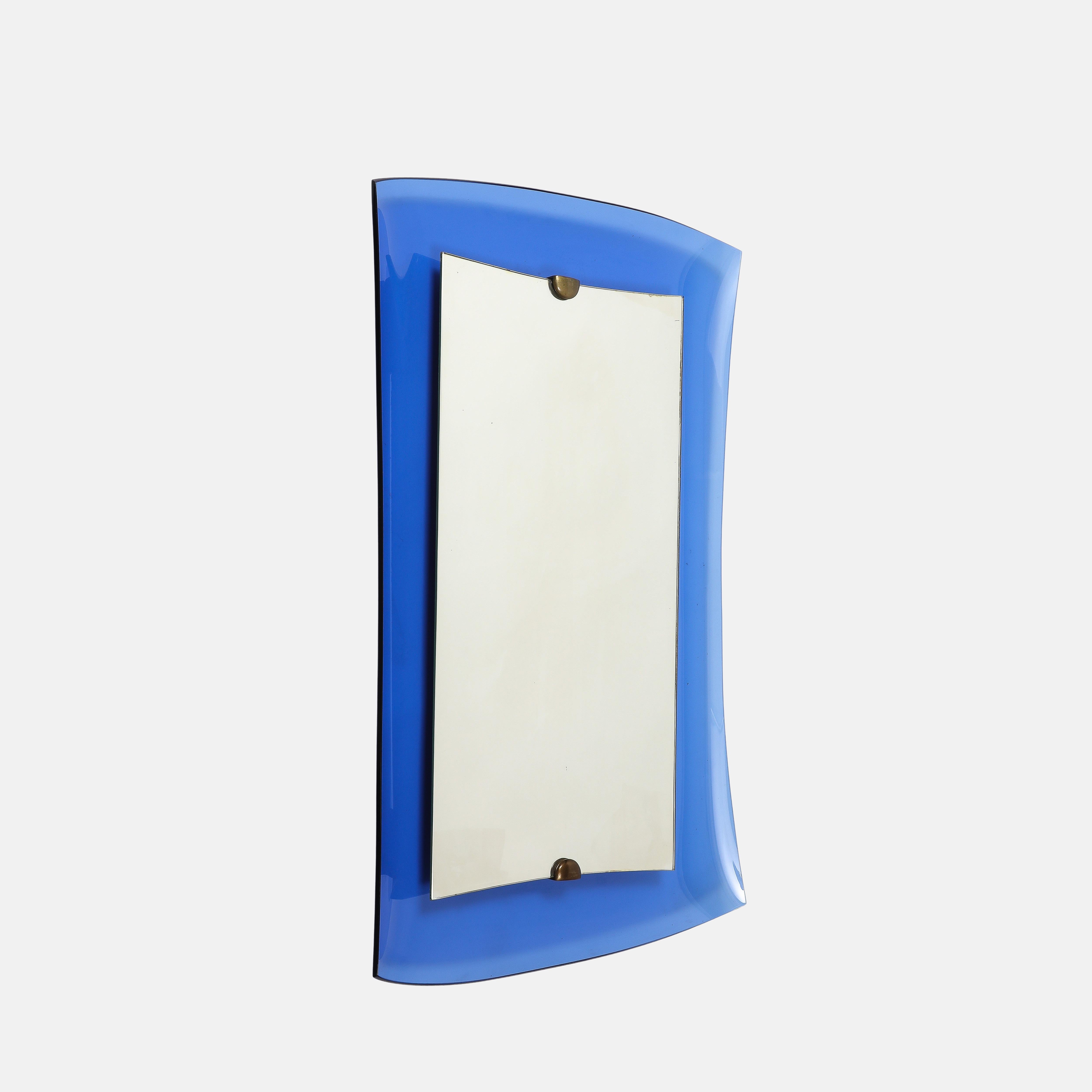 Cristal Art rectangular mirror model 2712 with thick blue concave crystal glass frame suspending central mirrored glass by elegant brass mounts on a wooden backing. This striking and chic mirror exudes modernism and sophistication, showing a sense