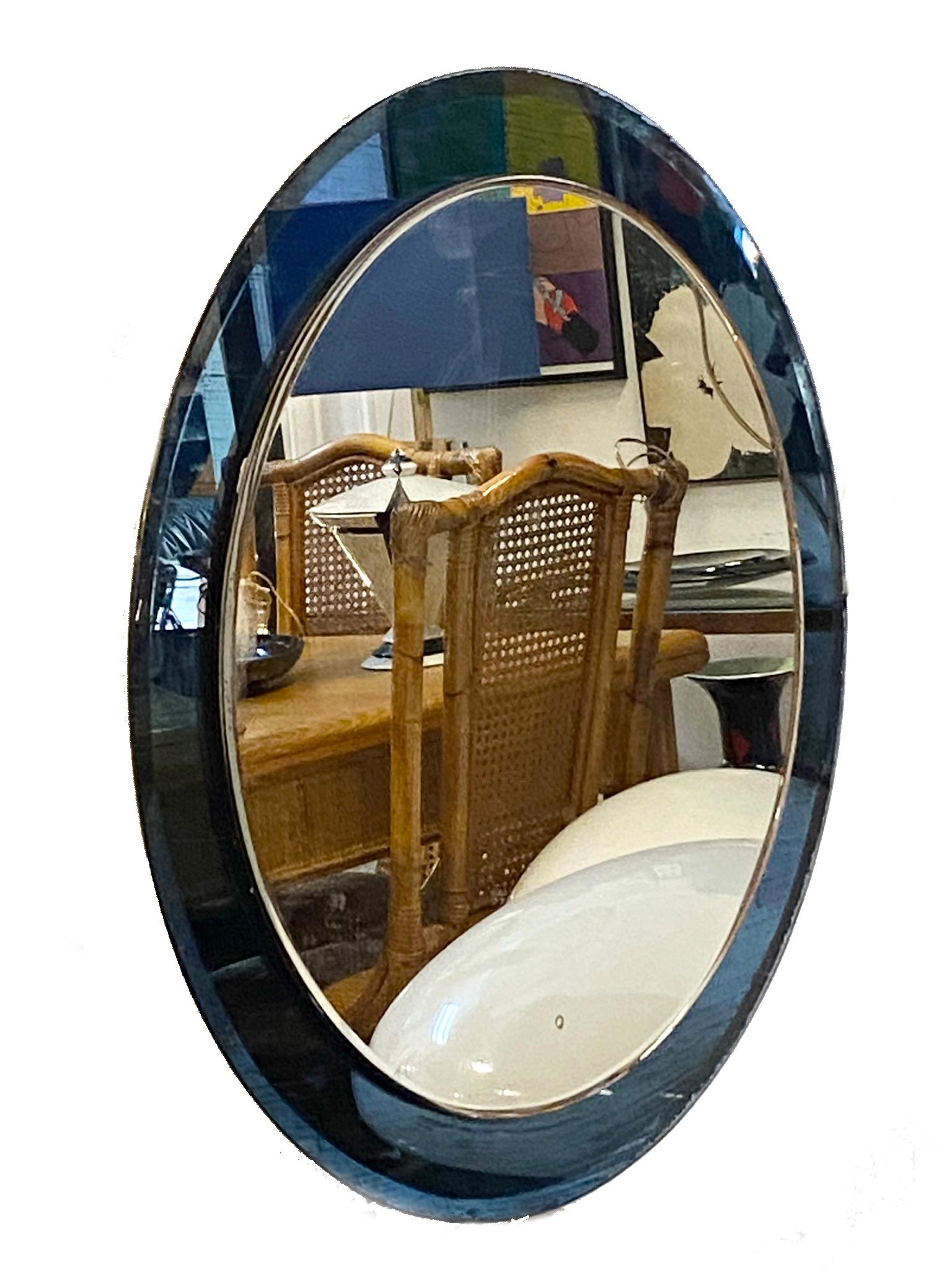 Incredible mid-century round double tier mirror with blue glass frame. This wonderful piece was produced in Italy in the 1960s and is attributed to Crystal Art.
In its pure and essential mid-century design and lines, this wonderful piece features a