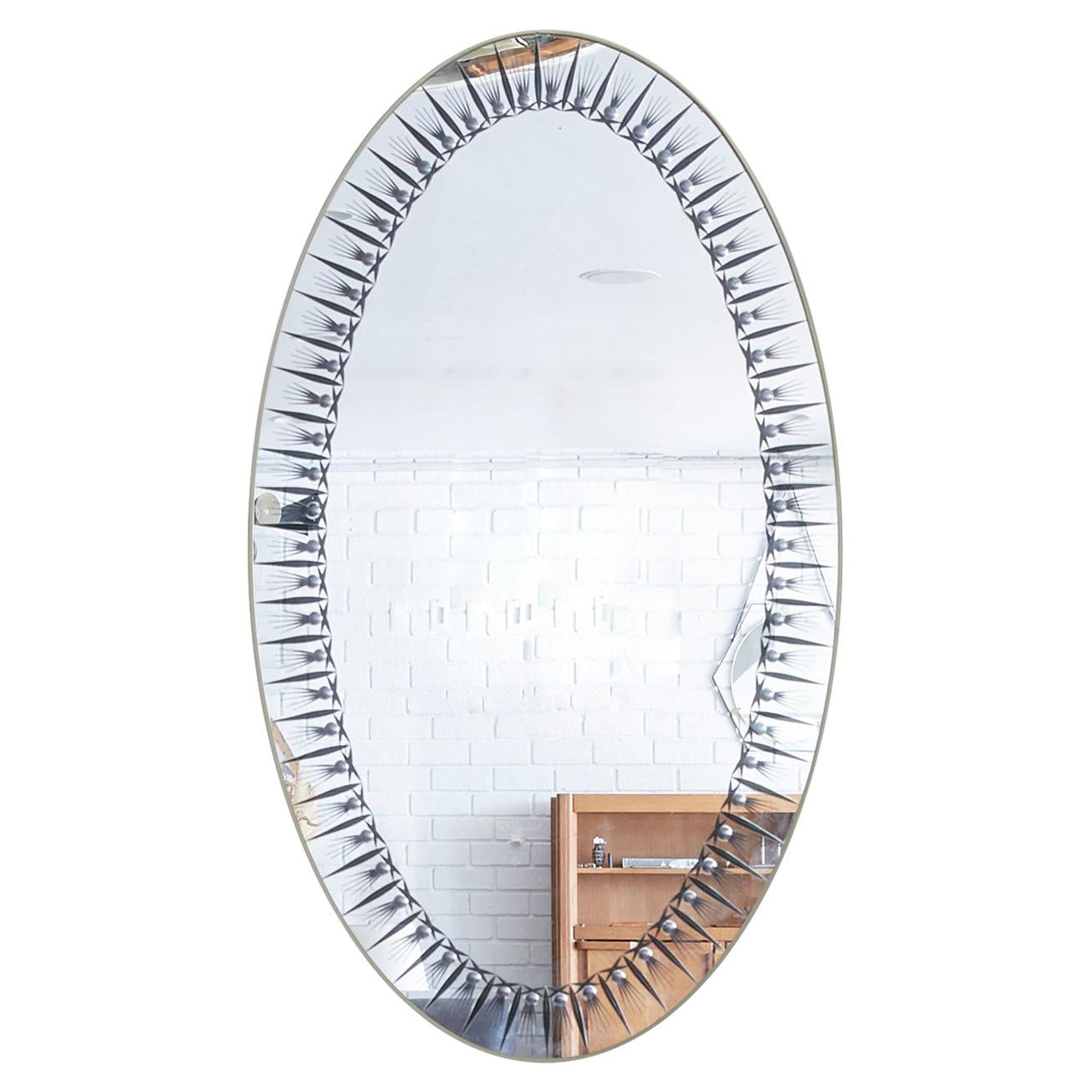 Gorgeous Cristal Arte oval mirror with grey frame border and brass trim. Beautiful patina throughout. Perfect bathroom vanity mirror!
   