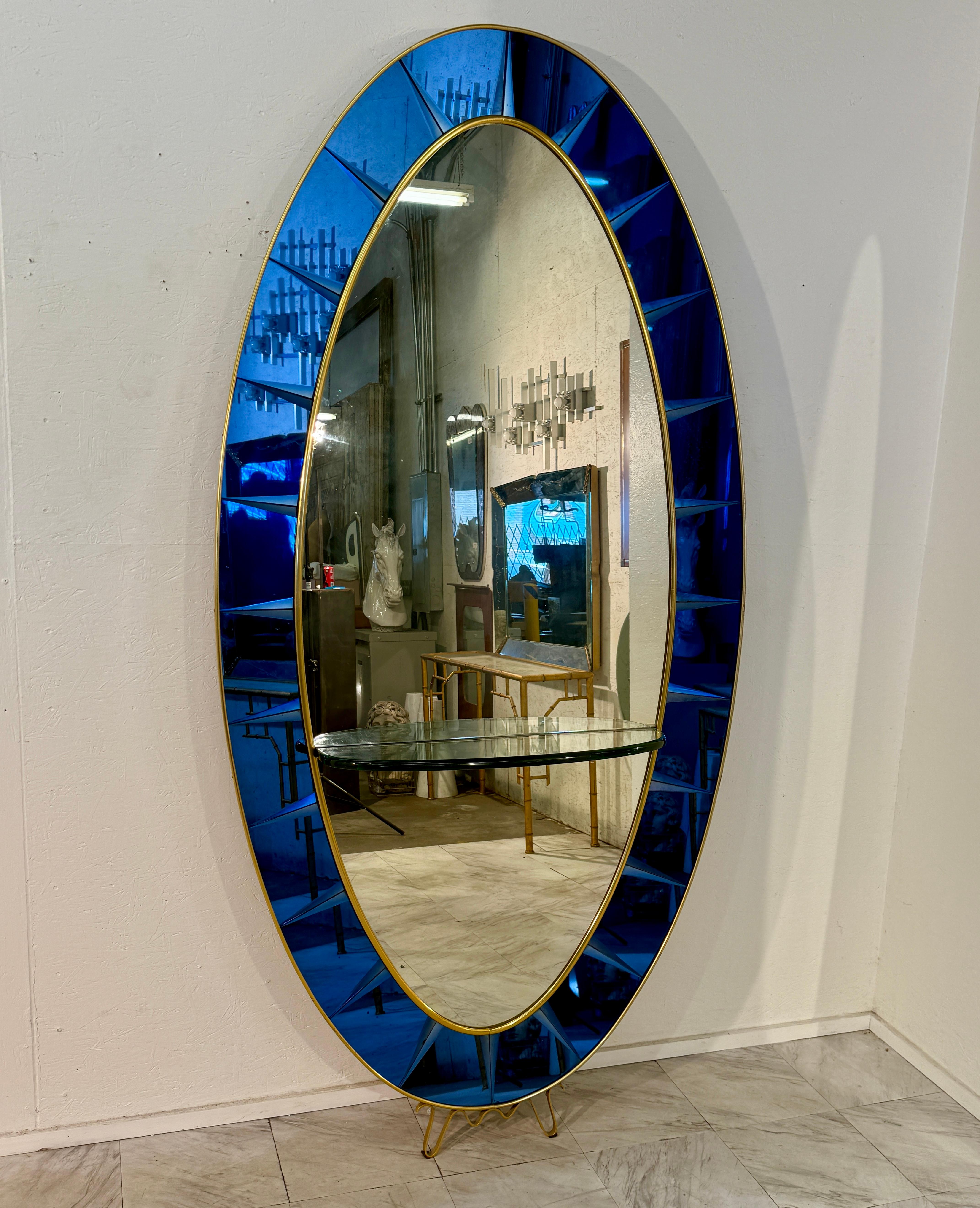 This stunning Cristal Art oval mirror is a sophisticated blend of functionality and artistry, designed to make a bold statement in any interior. The centerpiece is a tall oval mirror framed by an outer border of striking deep cobalt-blue mirrored