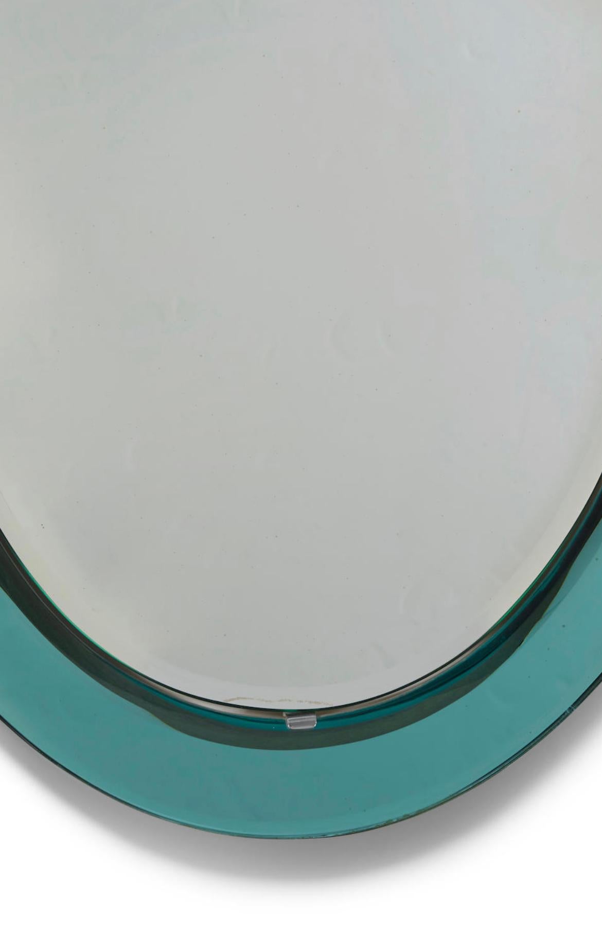 Oval wall mirror by Cristal Arte (Founded 1944). Colored and clear mirrored glass, chromed metal. Italy, 1950s.