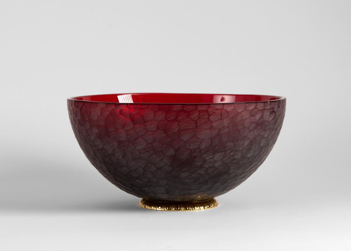 A ruby-red bowl with a bronze band around its foot, the exterior a honeycomb texture. Cut from glass crystal, this extraordinary piece exemplifies Martin Benito's mastery of a craft honed by his family for generations in France.

Benito begins his