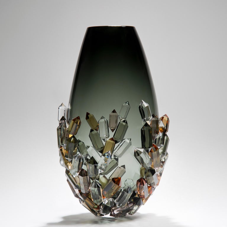 Cristallized Golden is a unique bronze, amber & grey glass sculptural vase by the Danish artist Hanne Enemark. The glass body has been hand-blown and painstakingly covered with cast and cut glass crystals, each made by hand by the artist

With