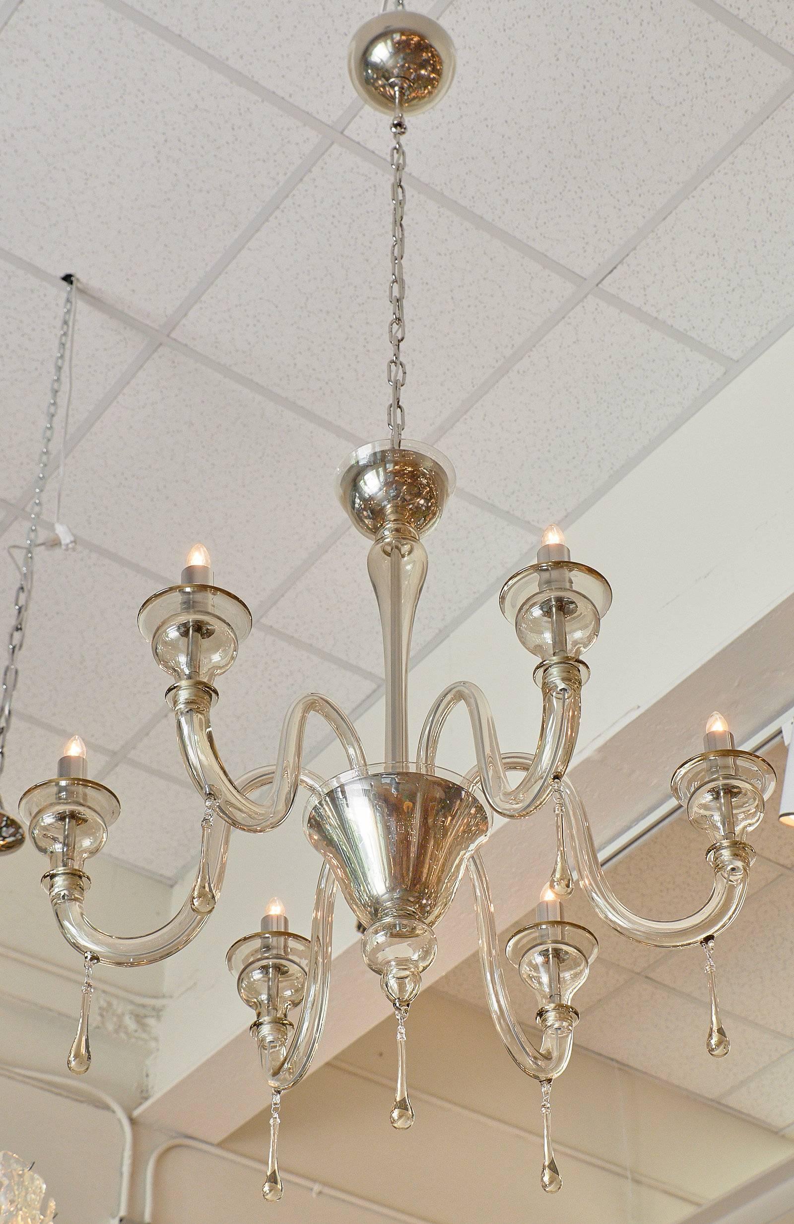 Elegant “Cristallo Antico” chandelier made of handblown Murano glass with a delicate smoked tint. It has six branches with pendants, blown bobêches. The cups and candelabras are chromed, giving this chandelier a more modern look, while the graceful