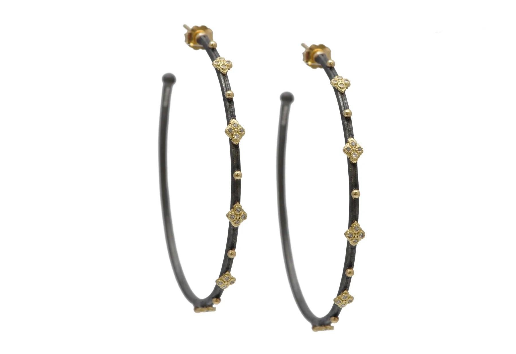 These beautiful 52 mm hoops are crafted in 18 karat yellow gold and blackened sterling silver.
The diamonds weigh a total of 0.24 carats. 


