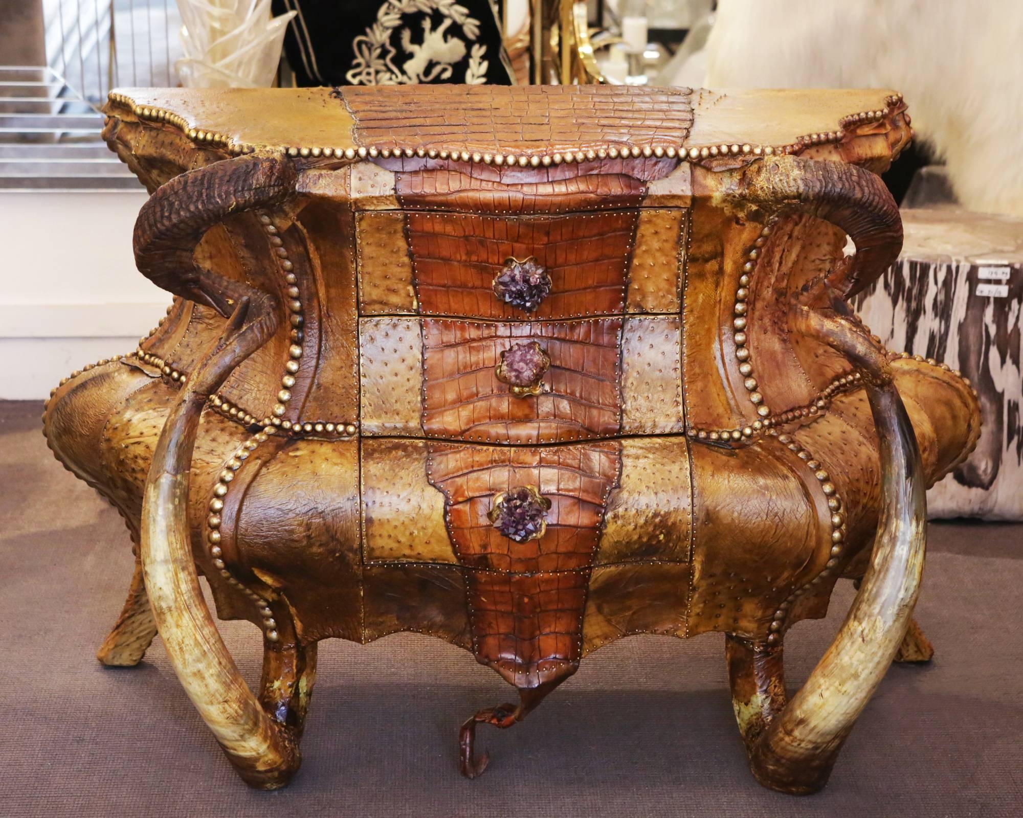 Chest of drawers crocodile and amethyst with structure
in solid beechwood and covered with real crocodile skin
and with genuine leather sides and back. With two real Aries
horns and two real Buffalo Water horns. With three drawers with
handles