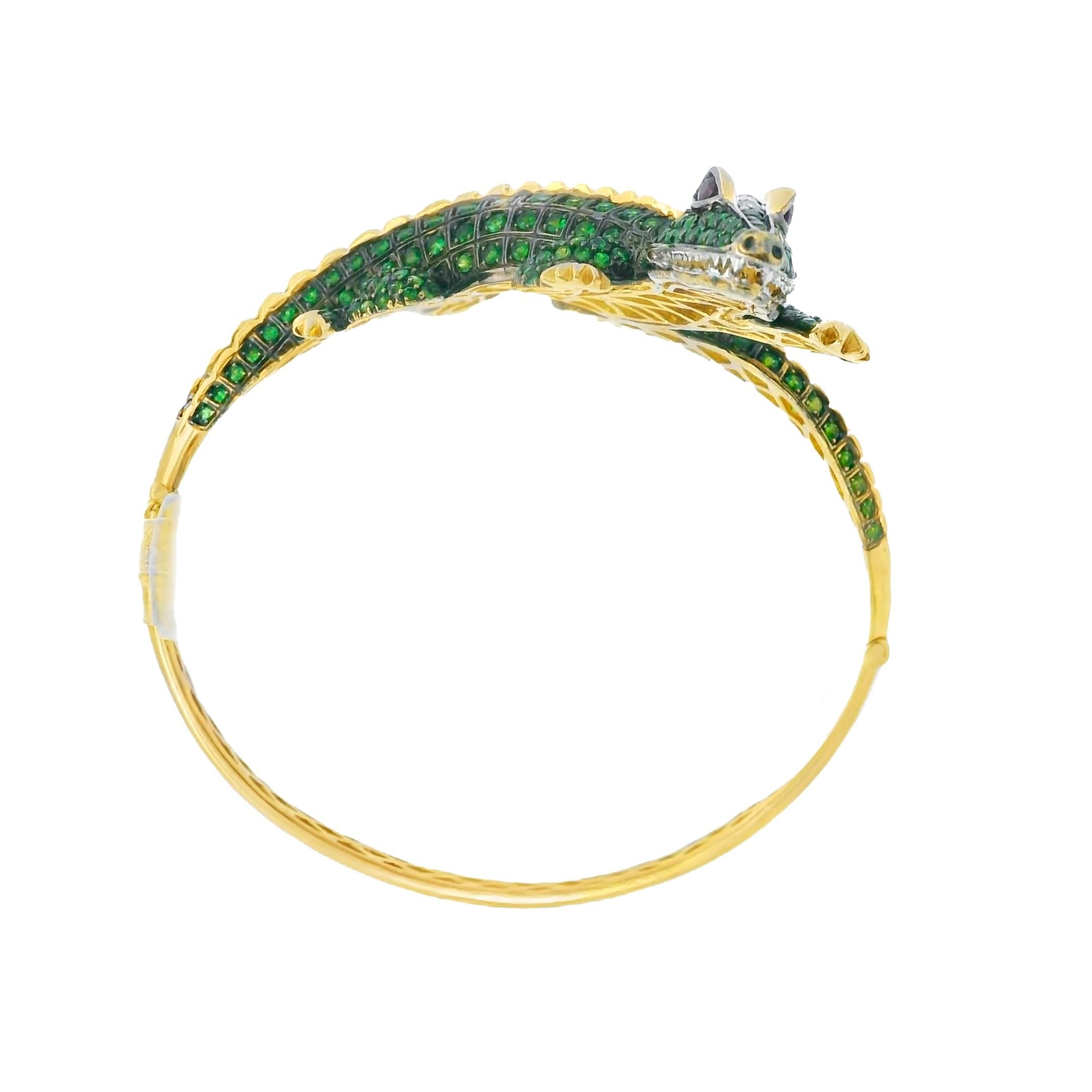 Bracelet en crocodile en or 18K - Audacieux, exotique, unique
Ce bracelet en crocodile est un véritable objet de conversation, fabriqué à la main à partir de 44 grammes d'or jaune 18 carats massif. Des grenats tsavorites d'un vert éclatant, taillés