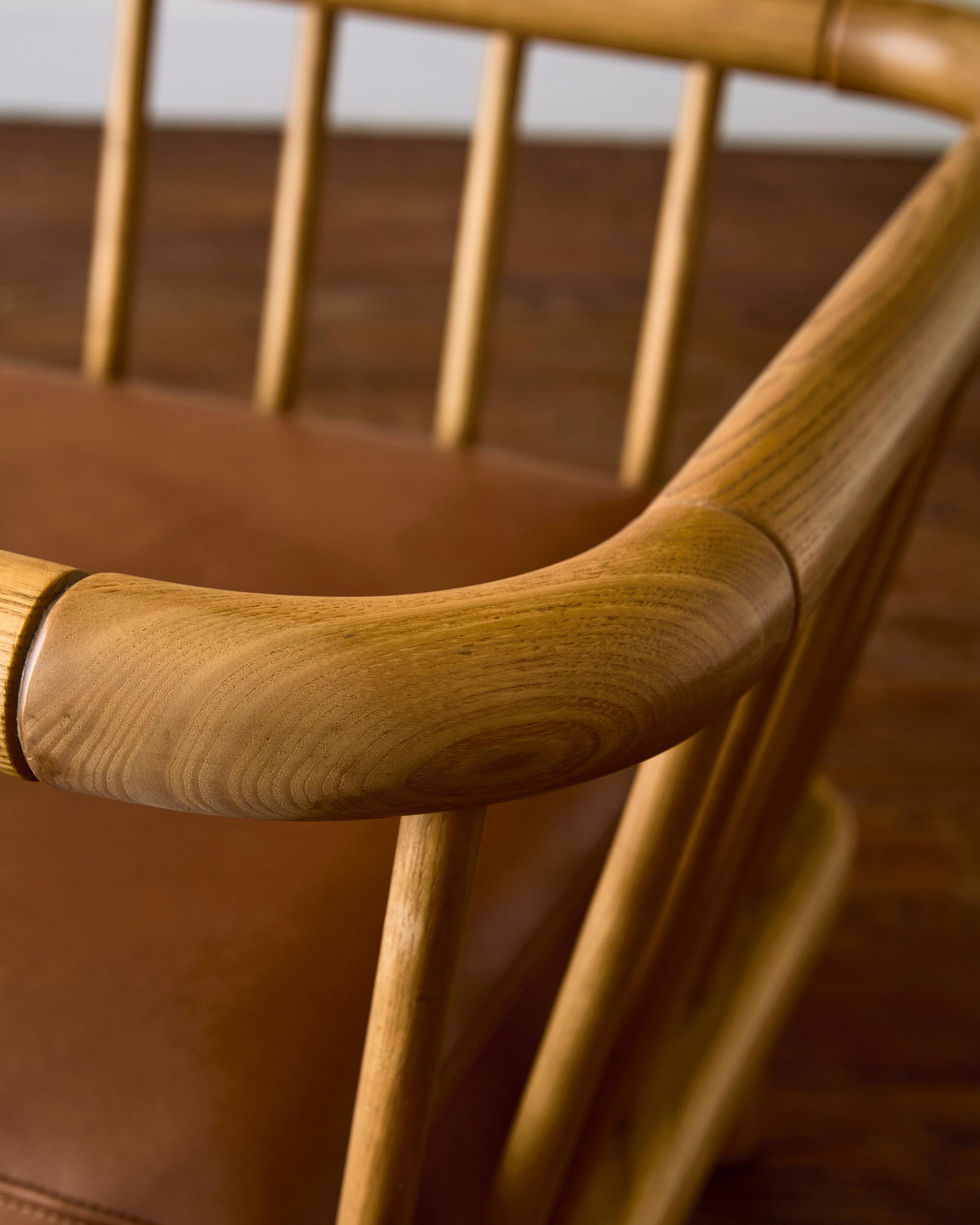 Sillón Croff de Ettore Sottsass para la serie Casa Nova, retapizado en piel marrón, con respaldo de madera de fresno.