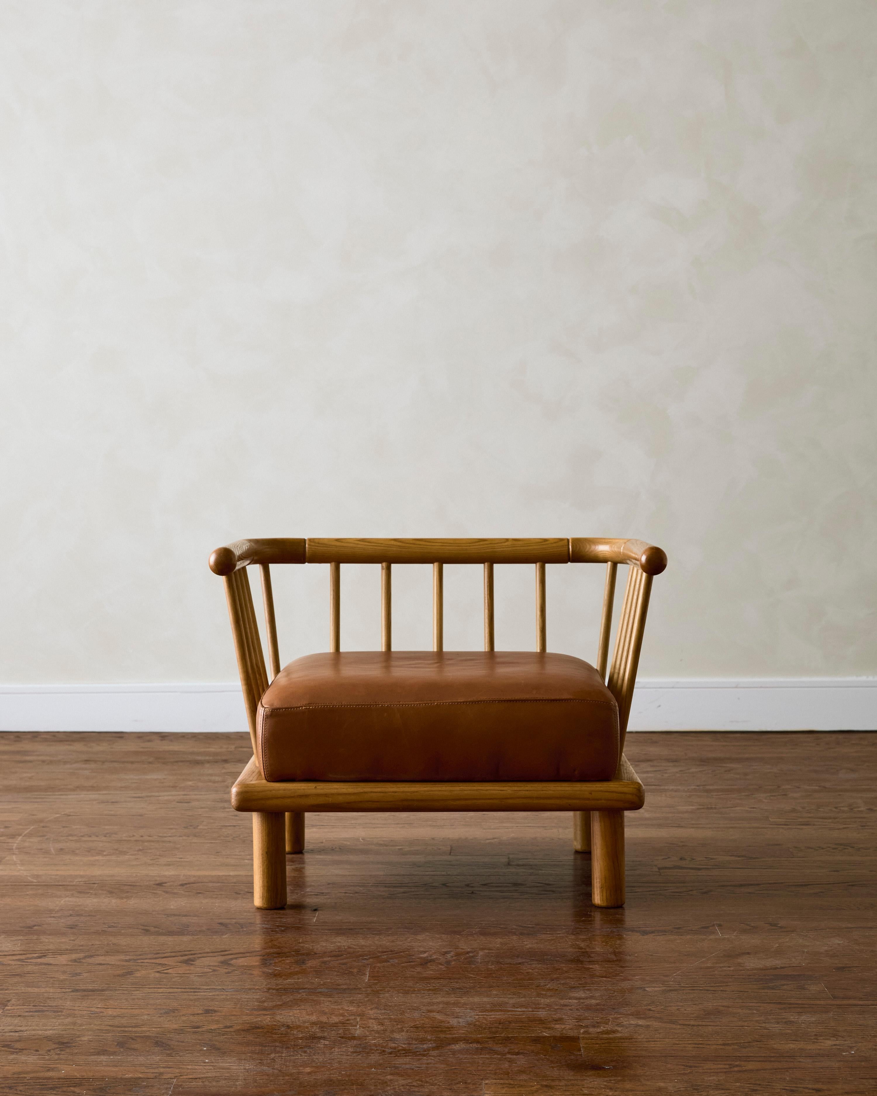 Poltrona Croff di Ettore Sottsass per la Serie Casa Nova, rivestita in pelle marrone, con schienale a fuso in legno di frassino.

Dimensioni: 22,83