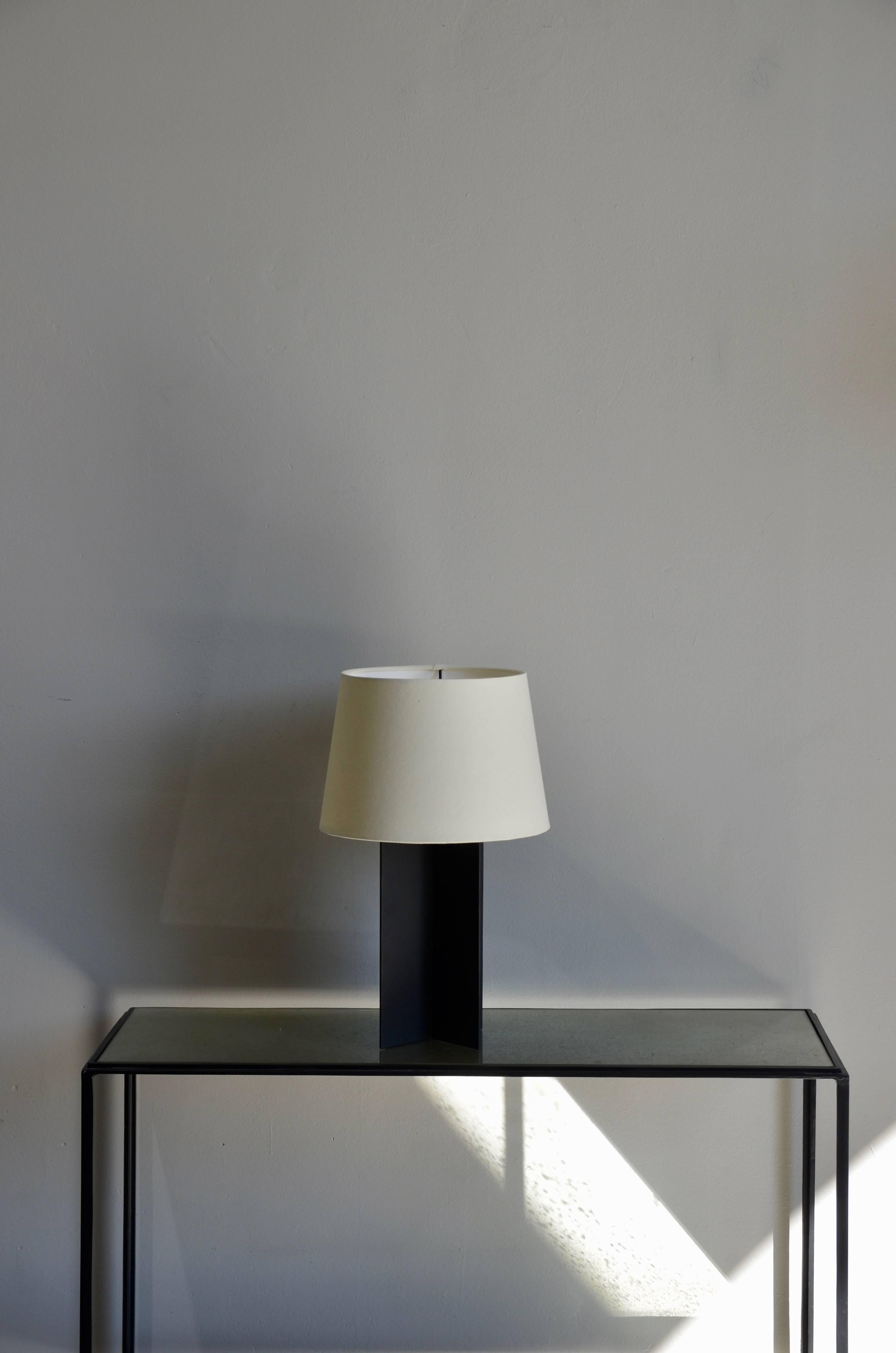 La lampe de table 'Croisillon' en acier noir mat de design Frères. Dans le style de Jean-Michel Frank. Abat-jour en parchemin crème personnalisé de style européen.

Cette lampe est exposée au Pebble Bar à New York.