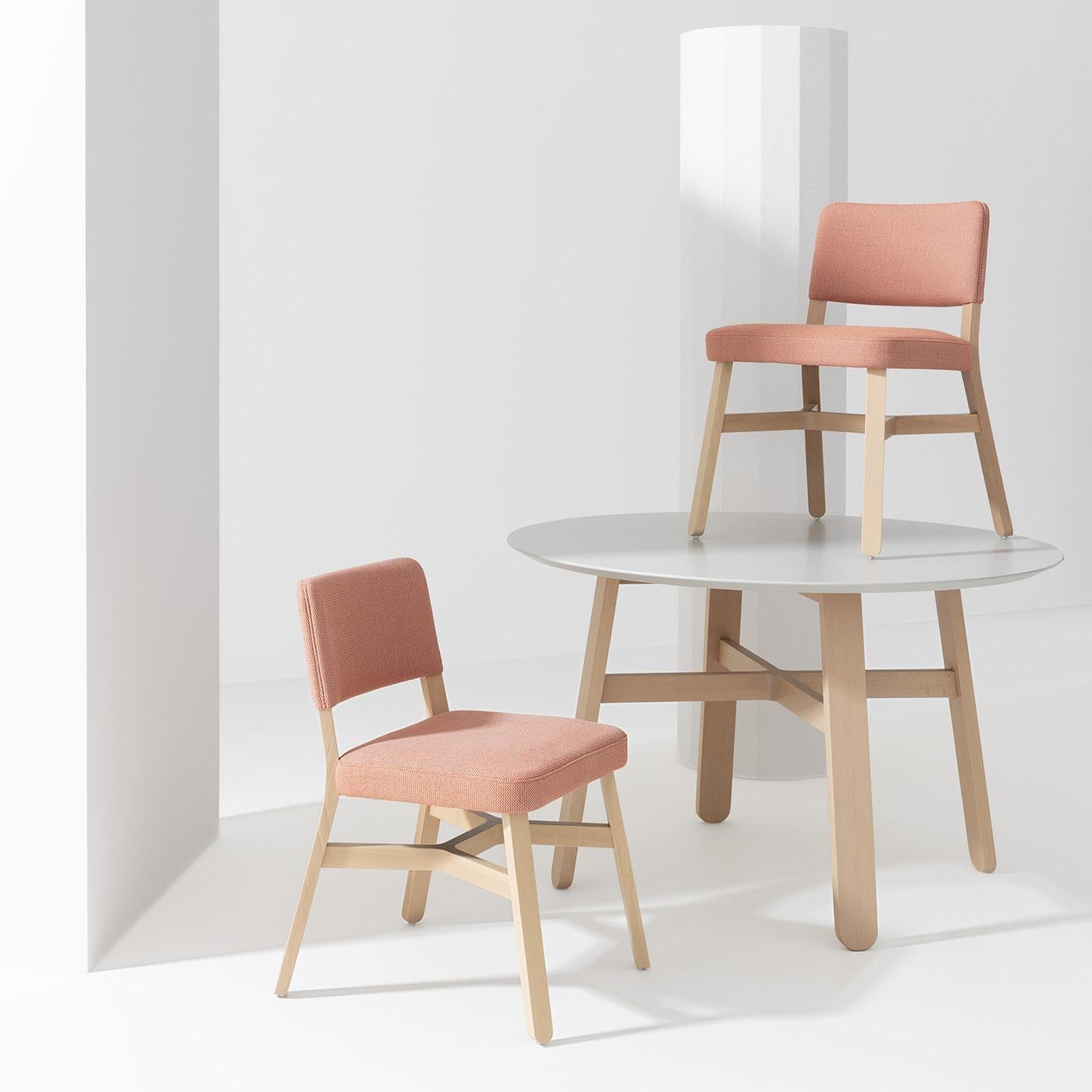 Showcasing the crossing structural element distinctive of the Croissant Collection, this exclusive beechwood chair designed by Emilio Nanni is a spot-on choice to add a pop of color to neutral-toned decors. The sleek frame is comprised of slender,