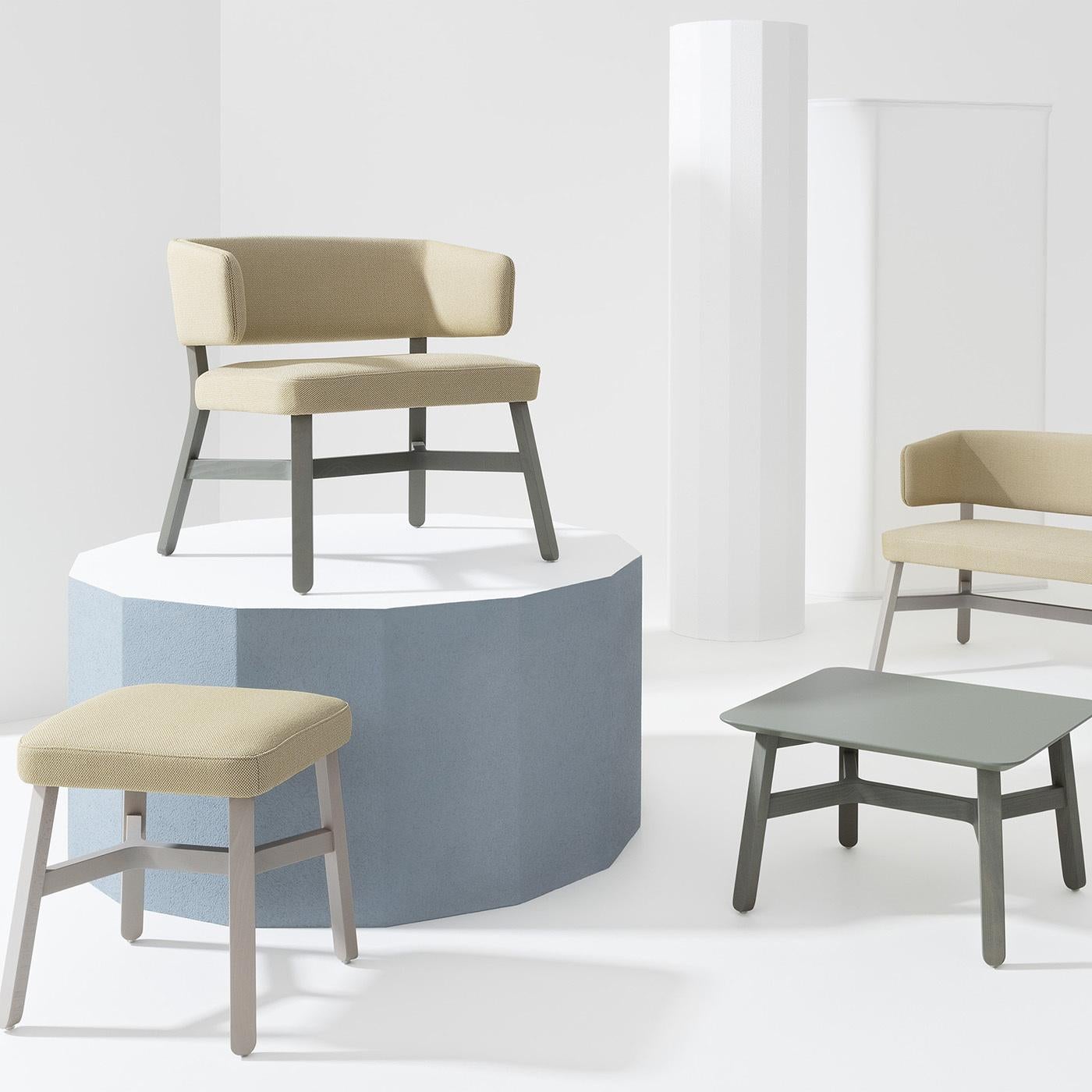 Dieser raffinierte Loungesessel aus massiver Buche lädt dazu ein, in Gesellschaft eines guten Buches Platz zu nehmen. Das zementgrau getönte Holzgestell besteht aus schrägen Beinen, die durch ein exklusives Kreuzungsdesign verbunden sind und eine
