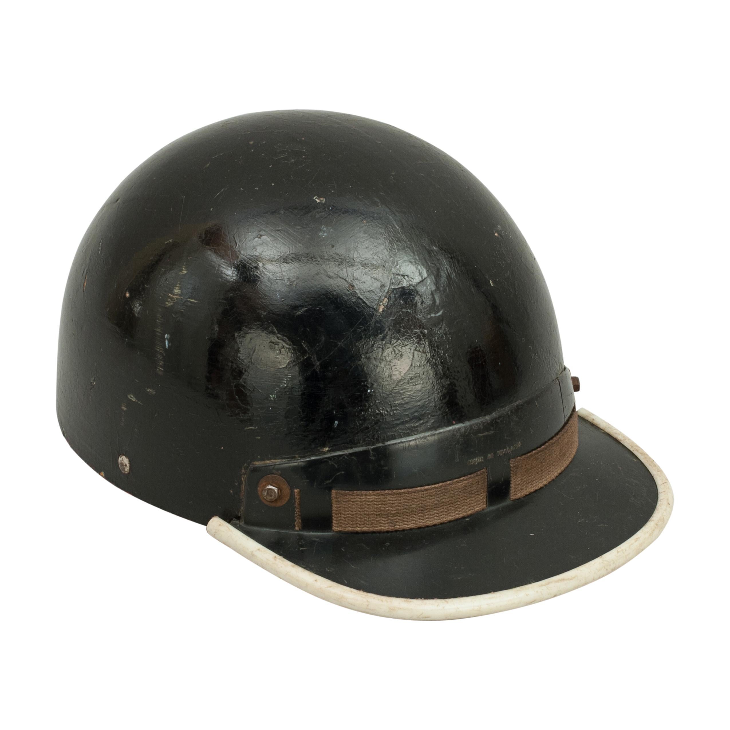 Vintage cromwell motoring helmet.
A good pudding basin motorcycle helmet with peak made in England by Cromwell. The outer shell is painted black with chips and scratches. The helmet interior is fitted with a material headband and webbing with