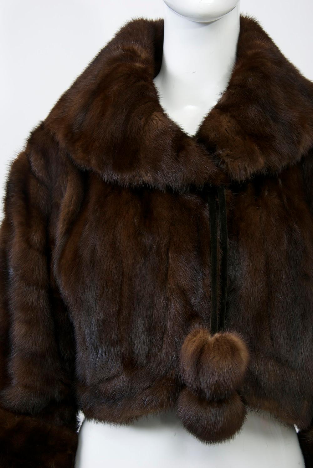 Mahogany mink waist-length jacket with shawl collar and sleeves that can be turned back with cuffs or let down for full length. Velvet cords terminating in mink spheres tie under the collar to hold the jacket closed. New silk charmeuse lining.