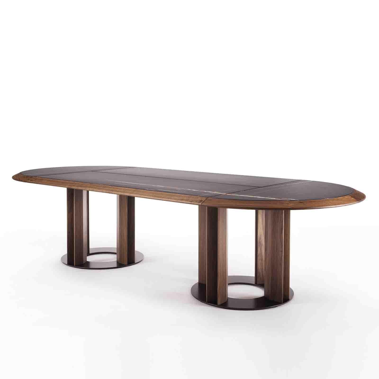 Dining table Crosby Oval Sahara Black with solid walnut 
wood base structure and top frame, with Sahara black marble 
top divided in four parts. With swivel walnut wood round tray.
Also available with solid walnut wood top or
brown emperador