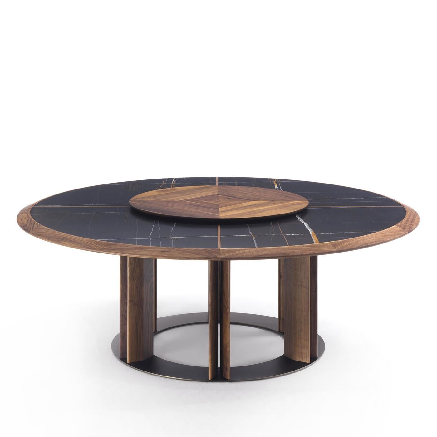 Table de repas ronde Crosby Sahara black avec noyer massif 
structure de base et cadre supérieur en bois, avec marbre noir Sahara 
sommet divisé en quatre parties. Avec plateau rond pivotant en bois de noyer.
Disponible en :
Diamètre 160cm x Hauteur