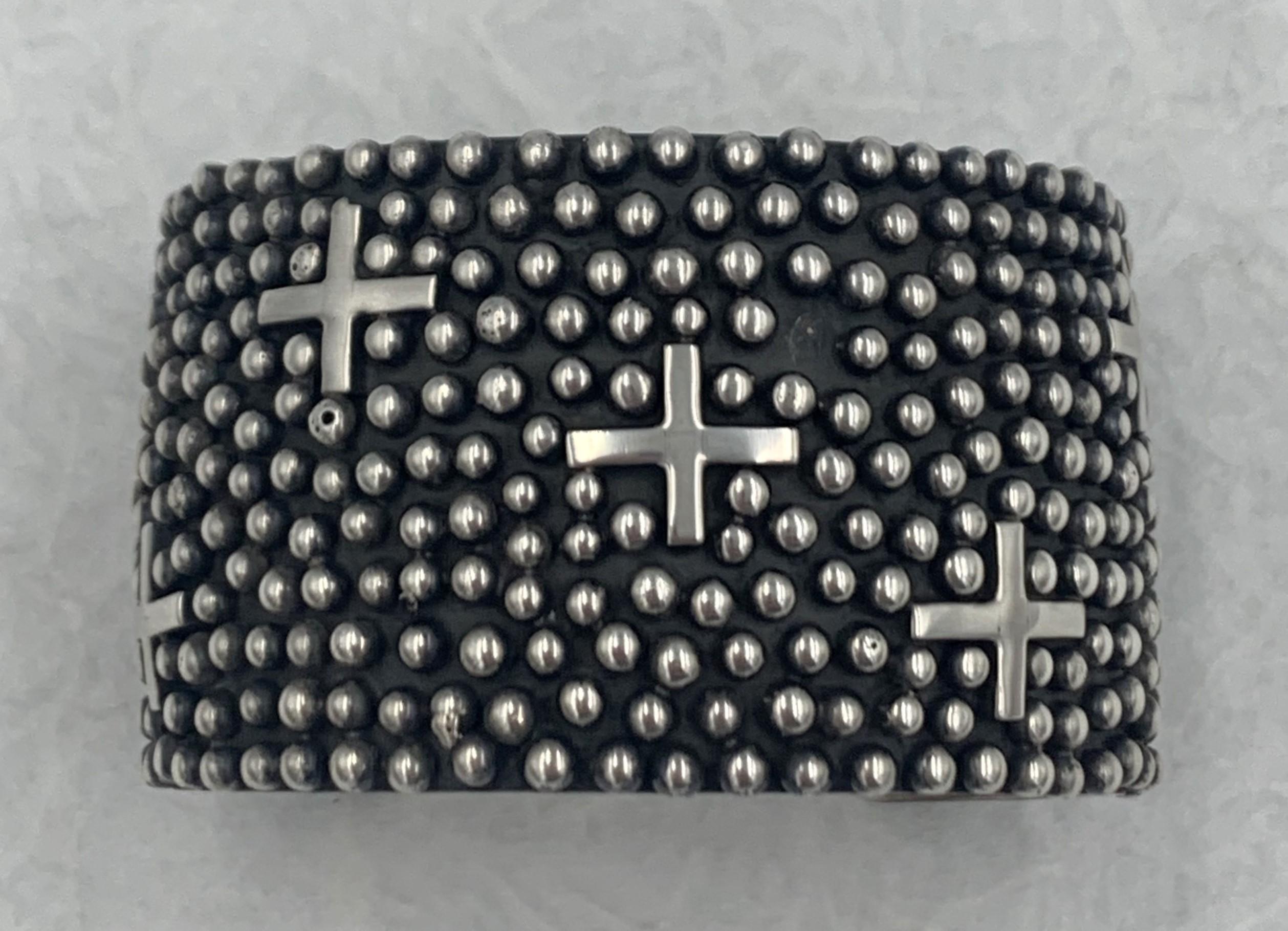 This bracelet is handcrafted by Navajo silversmith Ronnie Ray Willie. This piece features that design with sterling silver crosses resting within the beads (raindrops). *one drop on the cuff is missing

The size, inside measurements of the cuff is 5