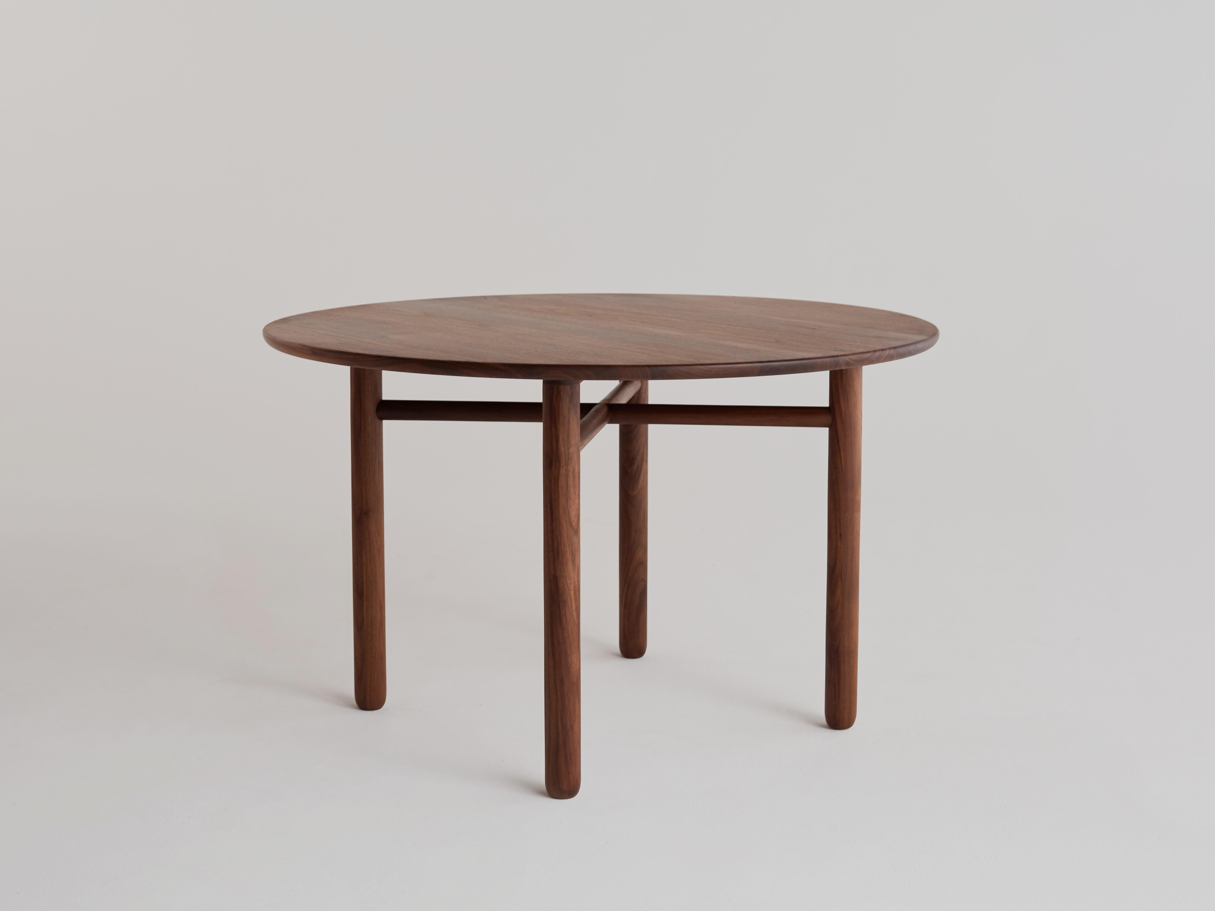 Cross bar table by Campagna, shown in walnut.

Refined and minimal, this round dining table has thickened, turned legs with a subtle, organic profile. The edge detail on the top is molded to the shape of the human hand and soft to the touch.