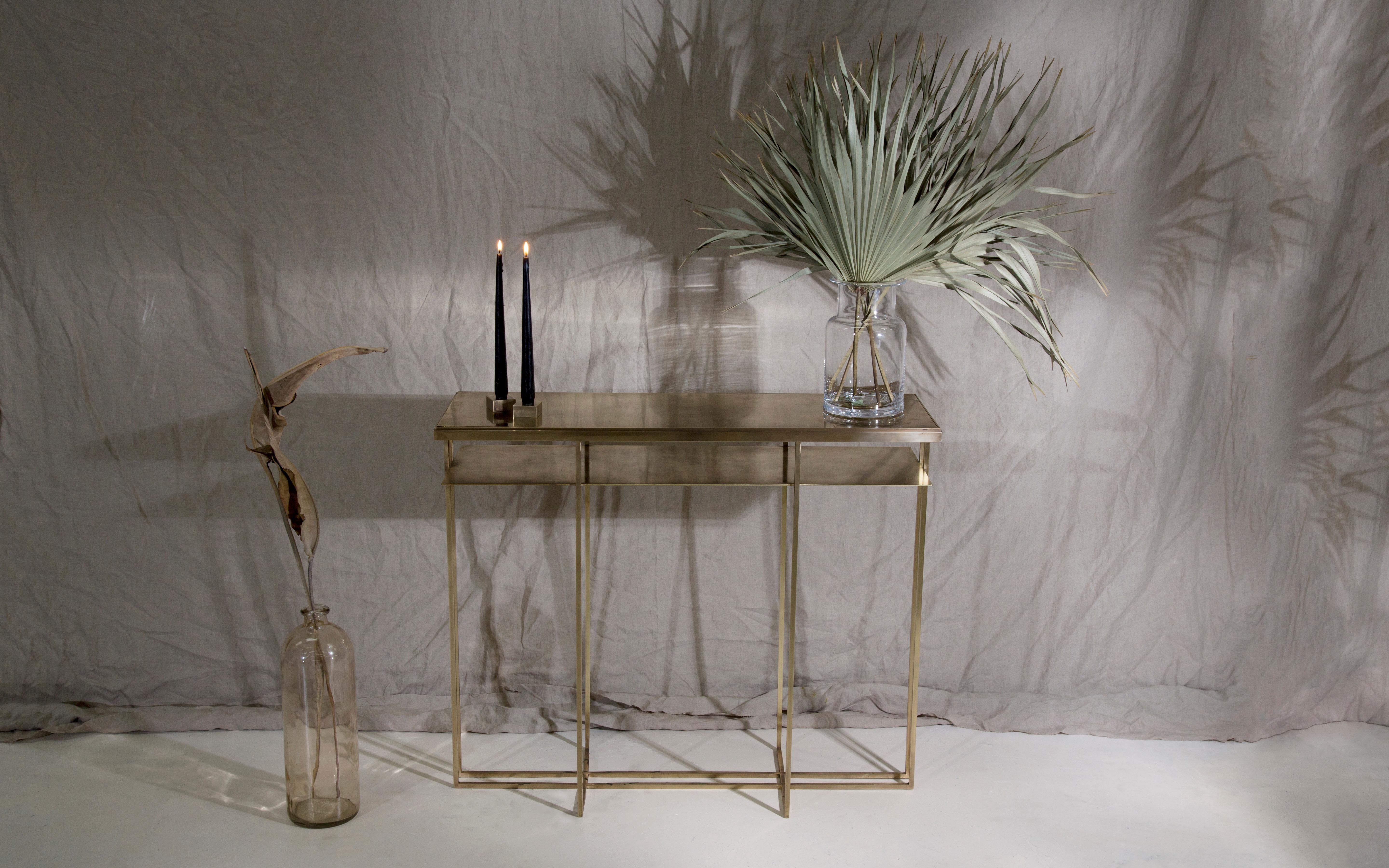 A side table in patinated brass, with a polished brass trim. Hand crafted in the North to order. Custom sizes and finishes are available.

Measures: 71cm (length) x 25cm (width) x 55cm (height). 
Custom sizes available.

Made to order in 12