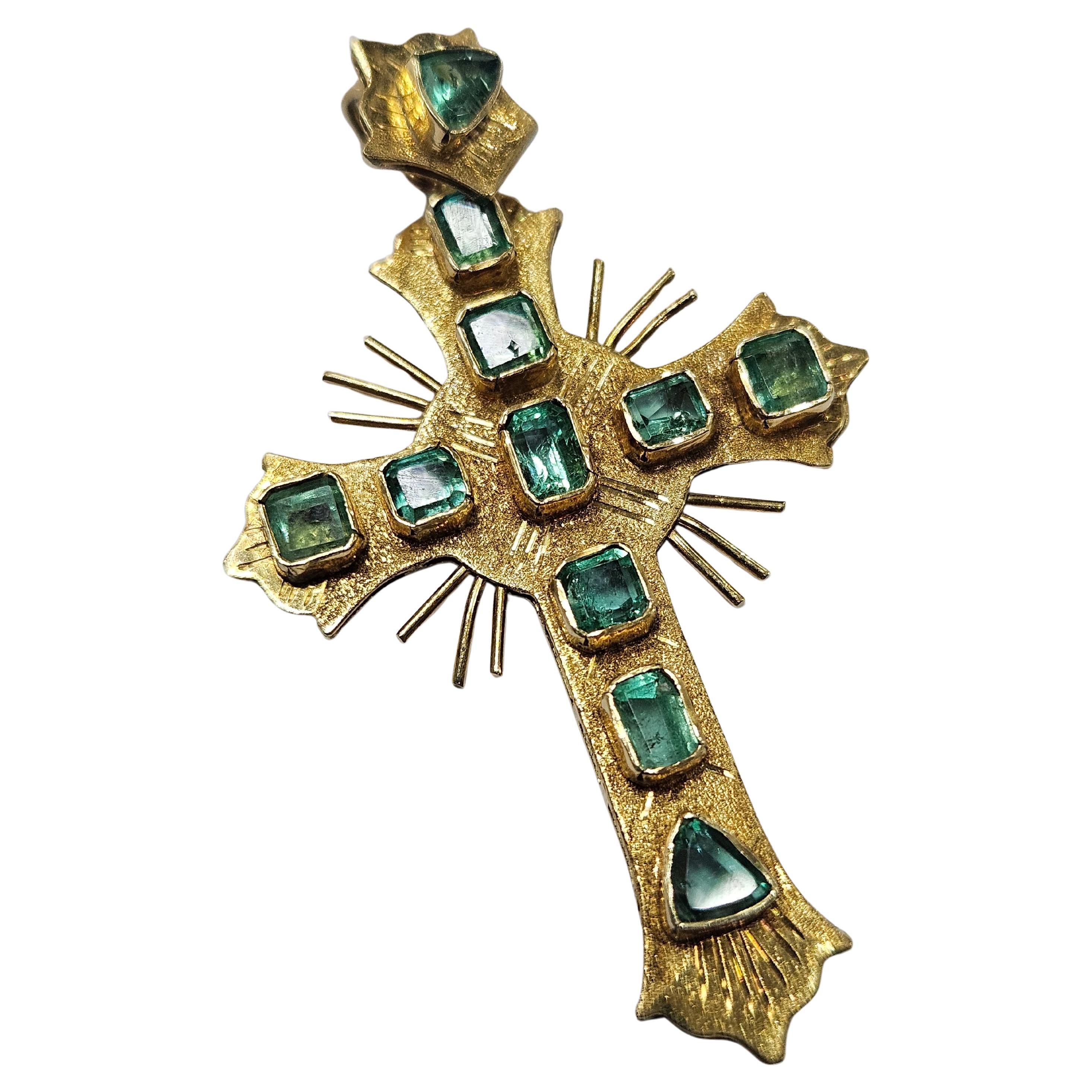 

Important colonial-style cross made of 18 Karat yellow gold, handmade with a very fine gallery and details engraved with buril. With 11 Natural Emerald trilliant cut and emerald cut: Origin Colombia quality AA. estimated total weight 2 cts. 
 Type