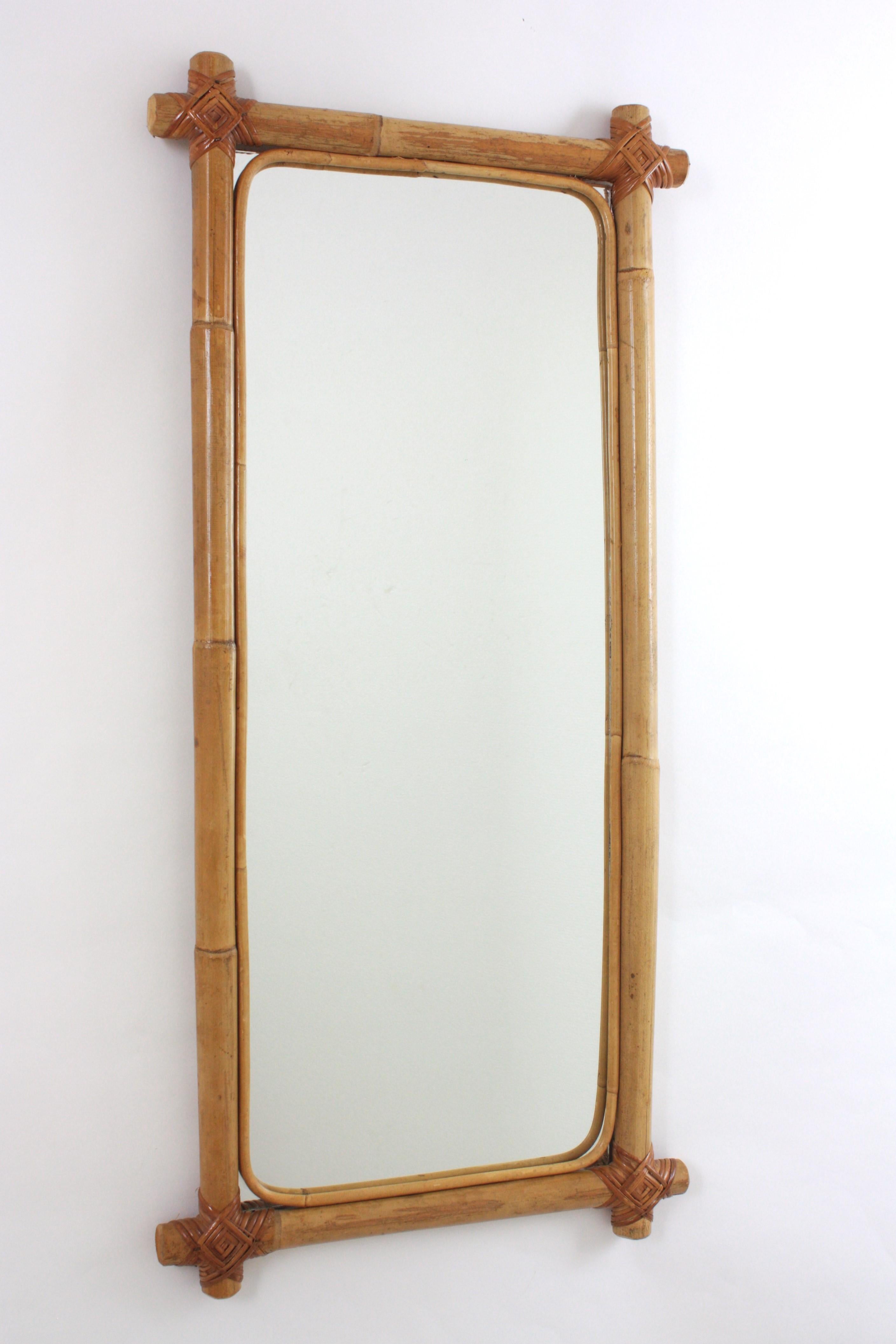 Rectangular tall mirror, bamboo, rattan, Spain, 1960s.
Eye-catching rectangular mirror handcrafted with bamboo cane. 
Rectangular frame made of bamboo / rattan cane with crossed corners with wicker stripe tied accents on the corners.
This mirror is