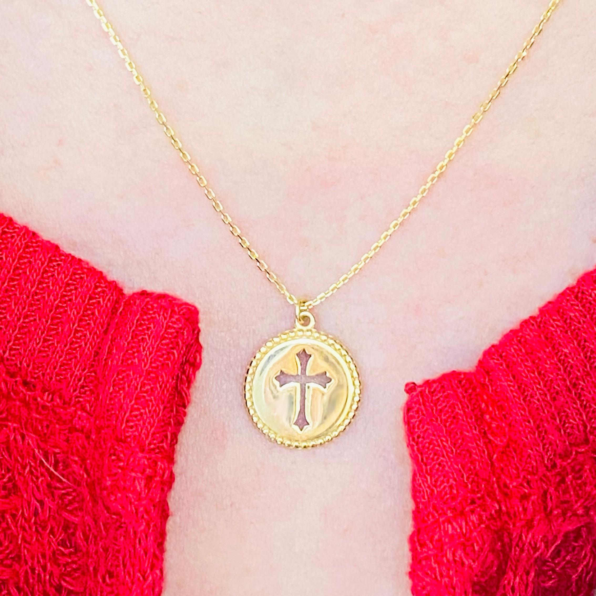 This gorgeous, intricate cross disk pendant is a stunning and striking design. The cross pendant is made in solid 14 karat yellow gold. The disk design has handmade millgrain texture. This pendant is on an 18 inch cable chain that compliments the