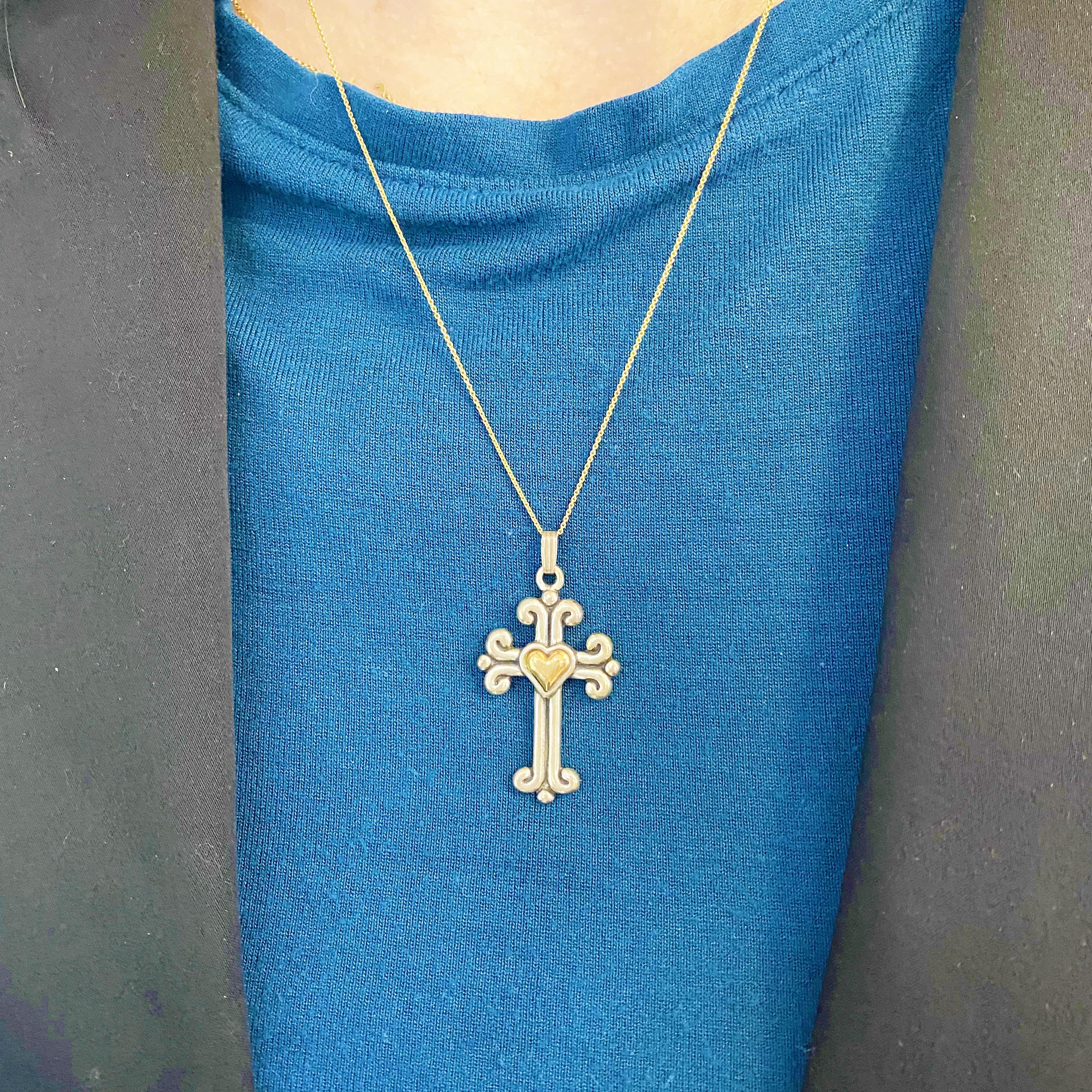Dieser wunderschöne, verschlungene Kreuz- und Herzanhänger ist ein atemberaubendes und auffälliges Design. Der Kreuzanhänger ist aus 14 Karat Gelbgold und Sterlingsilber gefertigt. Diese Halskette ist das perfekte Geschenk für einen lieben Menschen