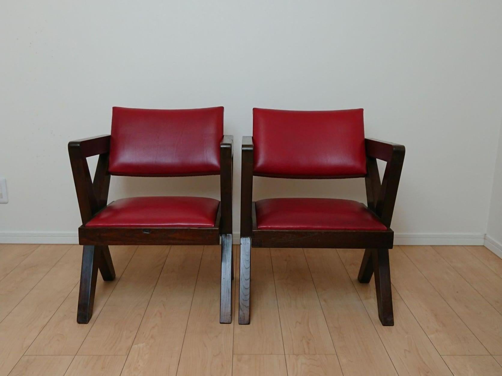Cross legs pair of armchairs designed Pierre Jeanneret for Chandigarh city, India. 
Solid teak wood and upholstered real leather rouge are in good original condition.
Good wear consistent with age and use.
