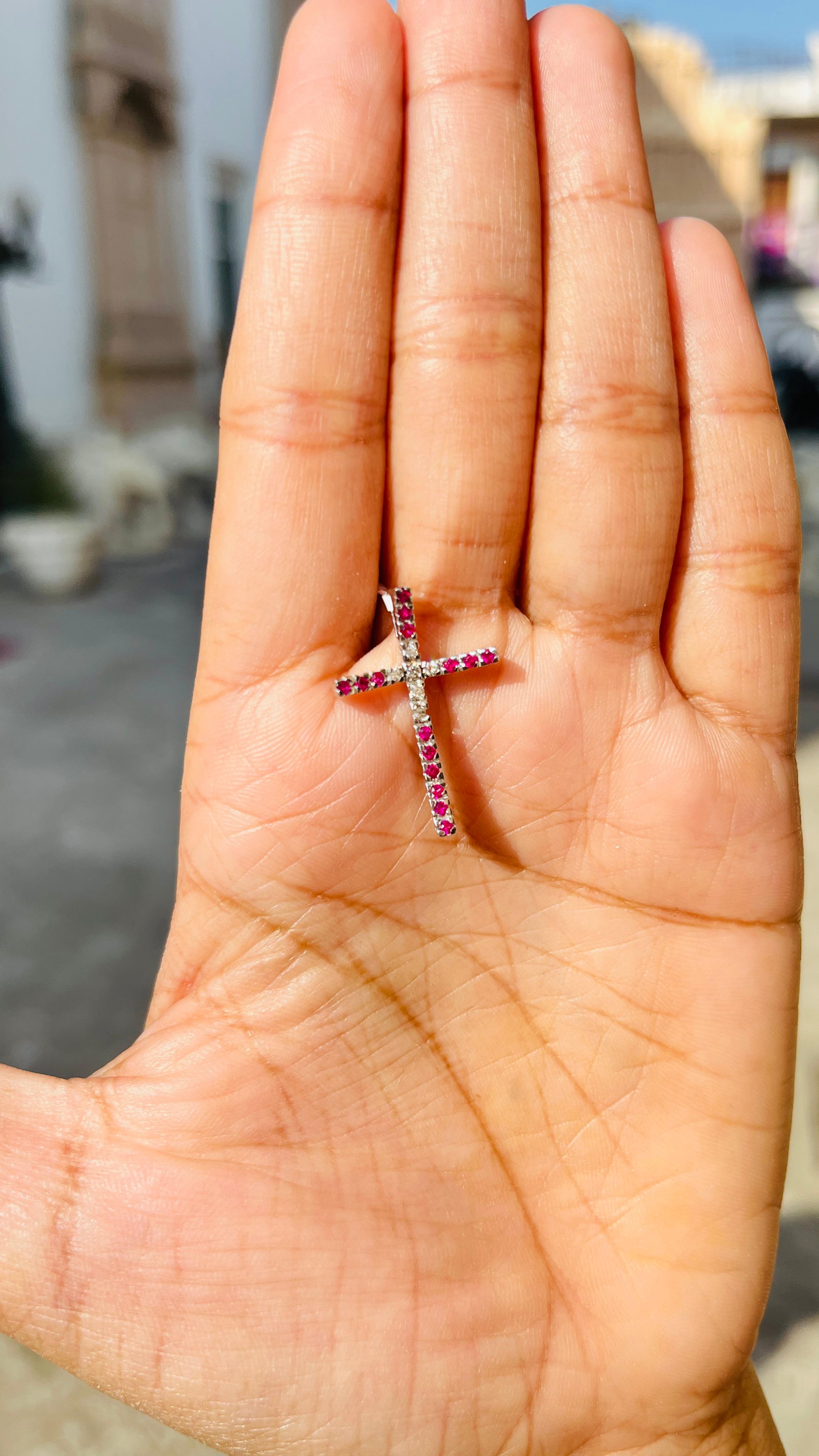 Diamond Ruby Cross Pendant in 18K Gold studded with round cut ruby. This stunning piece of jewelry instantly elevates a casual look or dressy outfit. 
Ruby improves mental strength. 
Designed with diamonds studded in center of the pendant and rubies