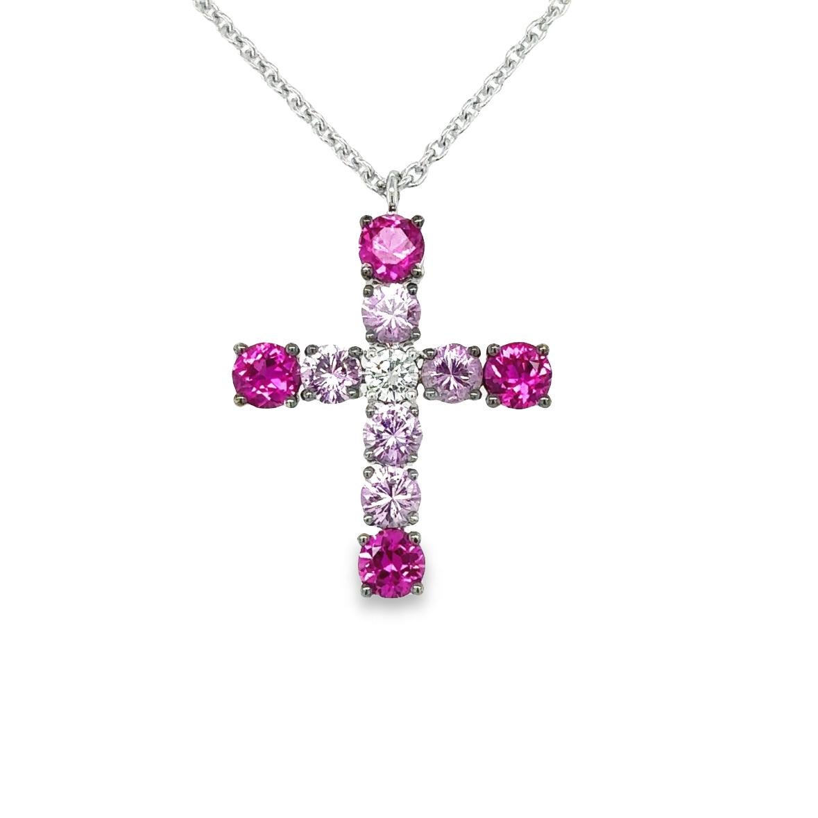 Presenting the TIMELESS Cross Necklace, skillfully crafted in 18Kt white gold with a weight of 5.60 grams. This exquisite piece features 4 Round Rubies, totaling 0.95 carats, alongside 5 Round Pink Sapphires, totaling 0.96 carats, and a Round