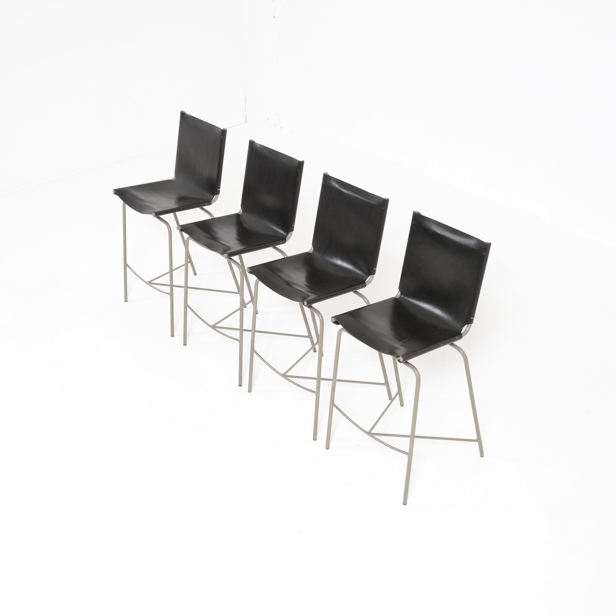 The crossed legs chair was designed by Fabian Van Severen in 1998.
These bar stools were manufactured in the designer’s atelier.
The thick leather seats are attached with laces to the grey coated tubular metal crossed legs base.
The stools are in