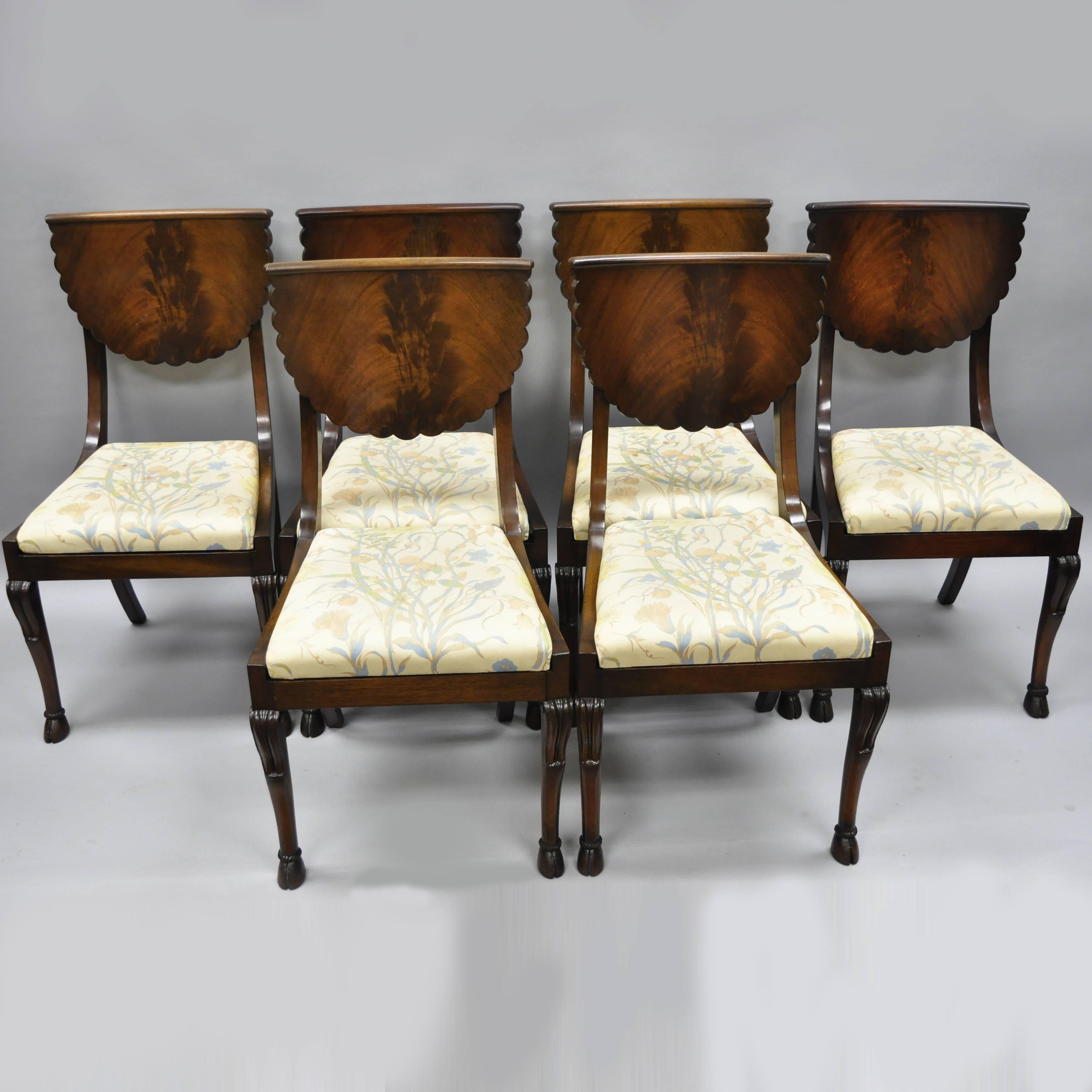 Set of six solid mahogany hoof foot regency style dining chairs. Item features six solid mahogany side chairs, hoof feet, crotch mahogany curved backs, drop in upholstered seats, shell / fan carved backs, beautiful wood grain, great style and form,