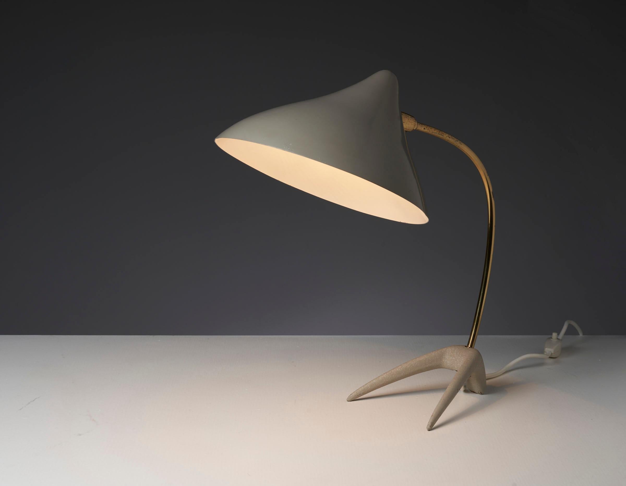 'Crowfoot' desk lamp, designed by Karl-Heinz Kinsky for Cosack in the 1950s. This table lamp is easily recognized by its particular tripod base, resembling a Crow's foot. It is made from cast iron which has a nice structure. The curved rod and joint