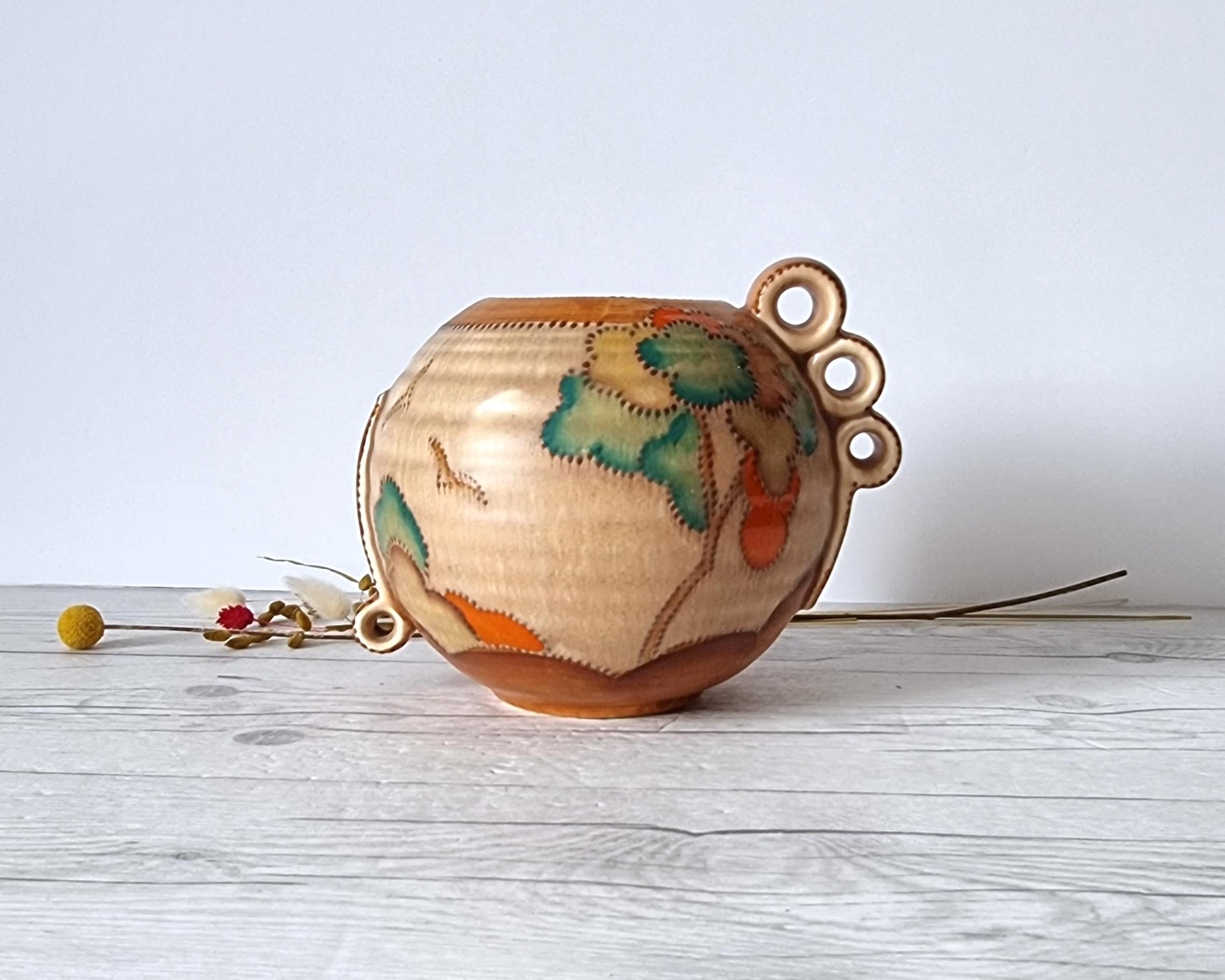 This beautifully stylised work of Art Deco design was made by English pottery Crown Devon. Designed and made during Clarice Cliff's Bizarre era. The stylised tree and landscape verdure décor in this piece echoes that of which appears in Cliff's
