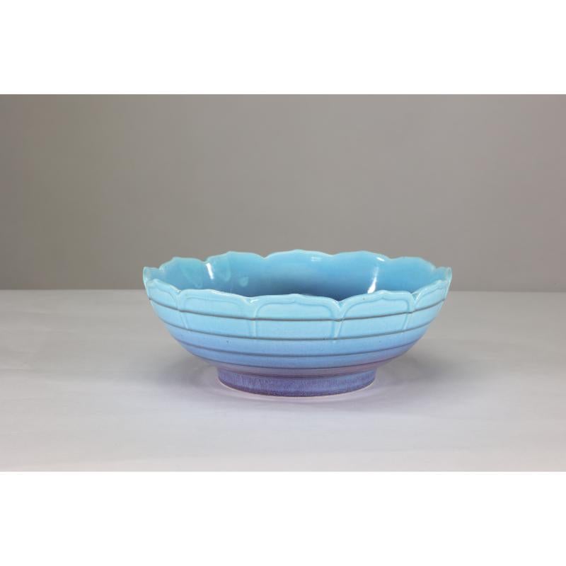 Crown Ducal. An Arts and Crafts style bowl with leaf style decoration to the rim and ribbed details graduating down with a ground blue color fading to lilac.
