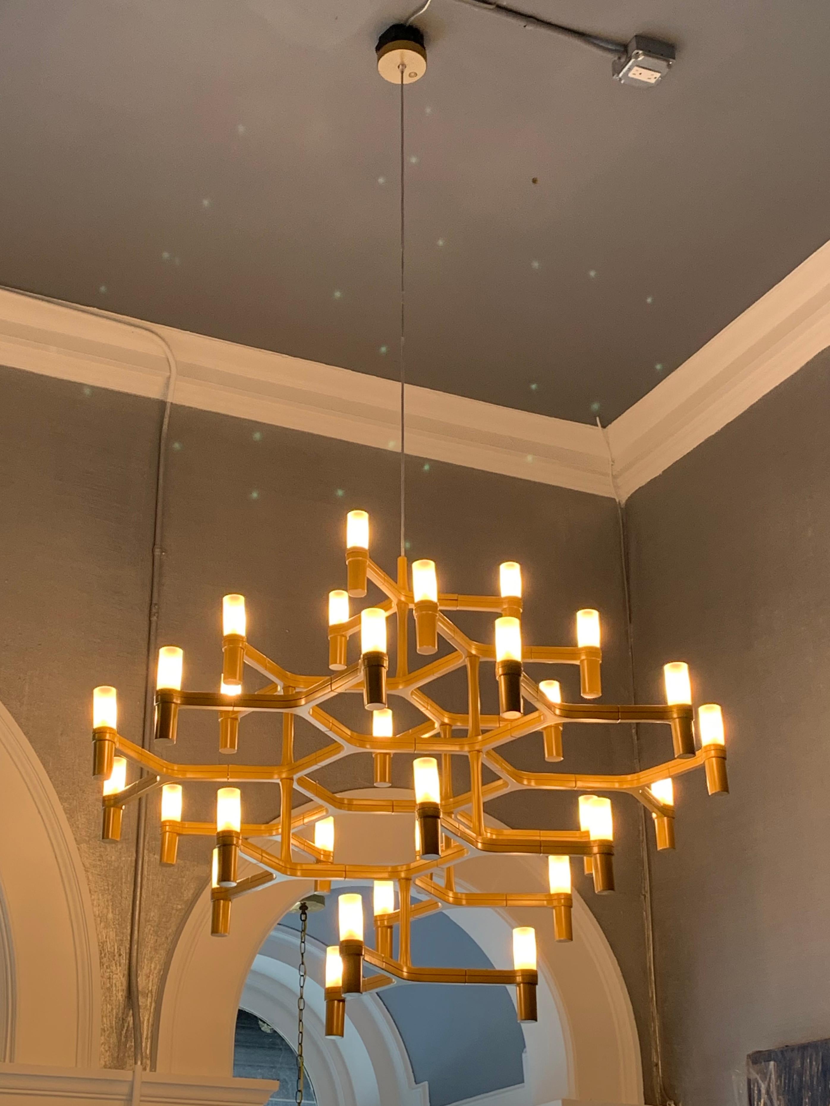 The Nemo crown major chandelier was designed by Jehs and Laub as a modern twist on the traditional candle chandelier. It is all straight lines and cylinders, from the die-cast aluminum arms and shade holders through the opal white glass shades. 30