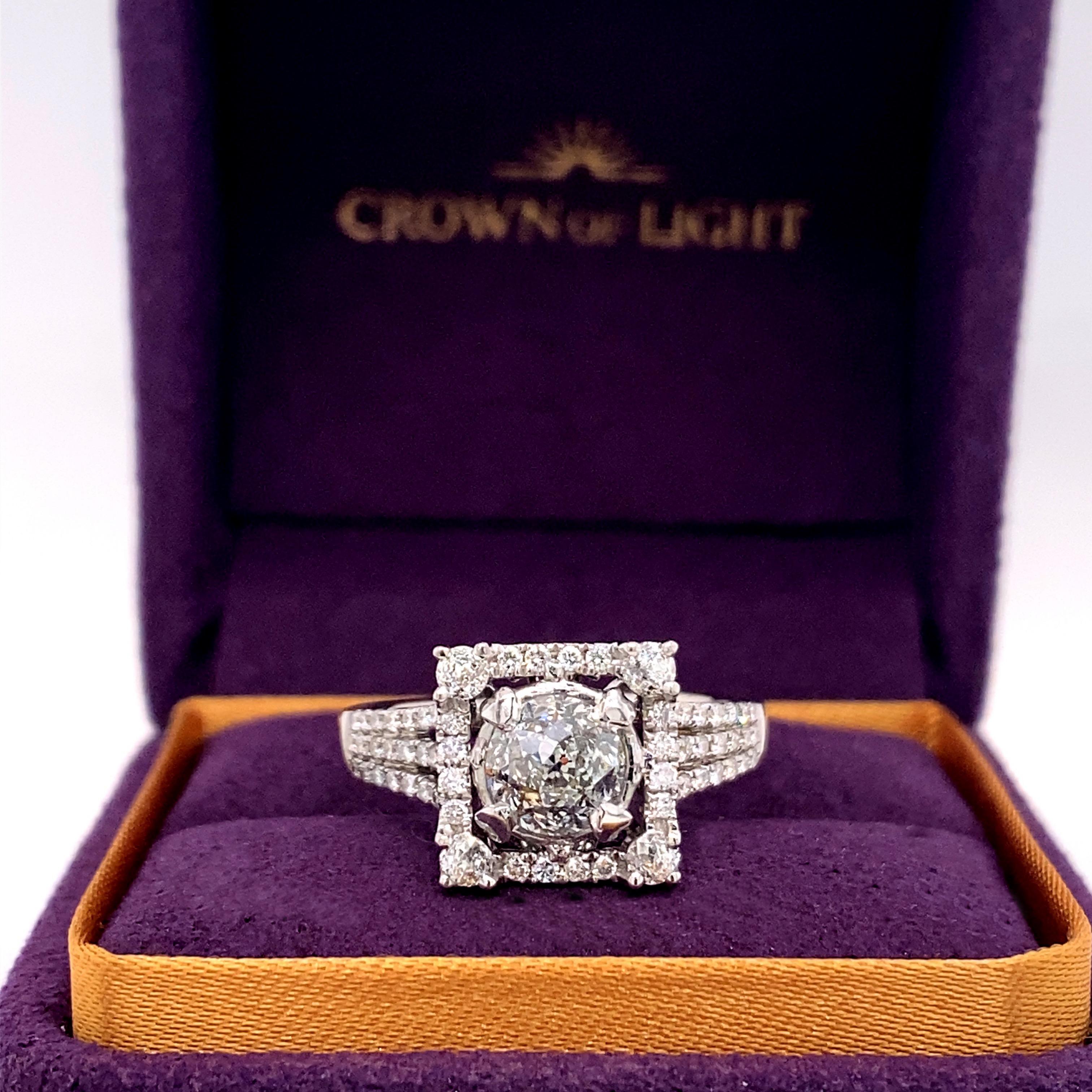 Crown of Light Round Diamond Engagement Ring
Style:  Halo
Metal:  14kt White Gold
Size:  8 - sizable
TCW:  1.86 tcw
Main Diamond:  Crown of Light Round Cut Diamond 1.22 cts
Color & Clarity:  J, VS1
Accent Diamonds:  Crown of Light Rounds 0.64