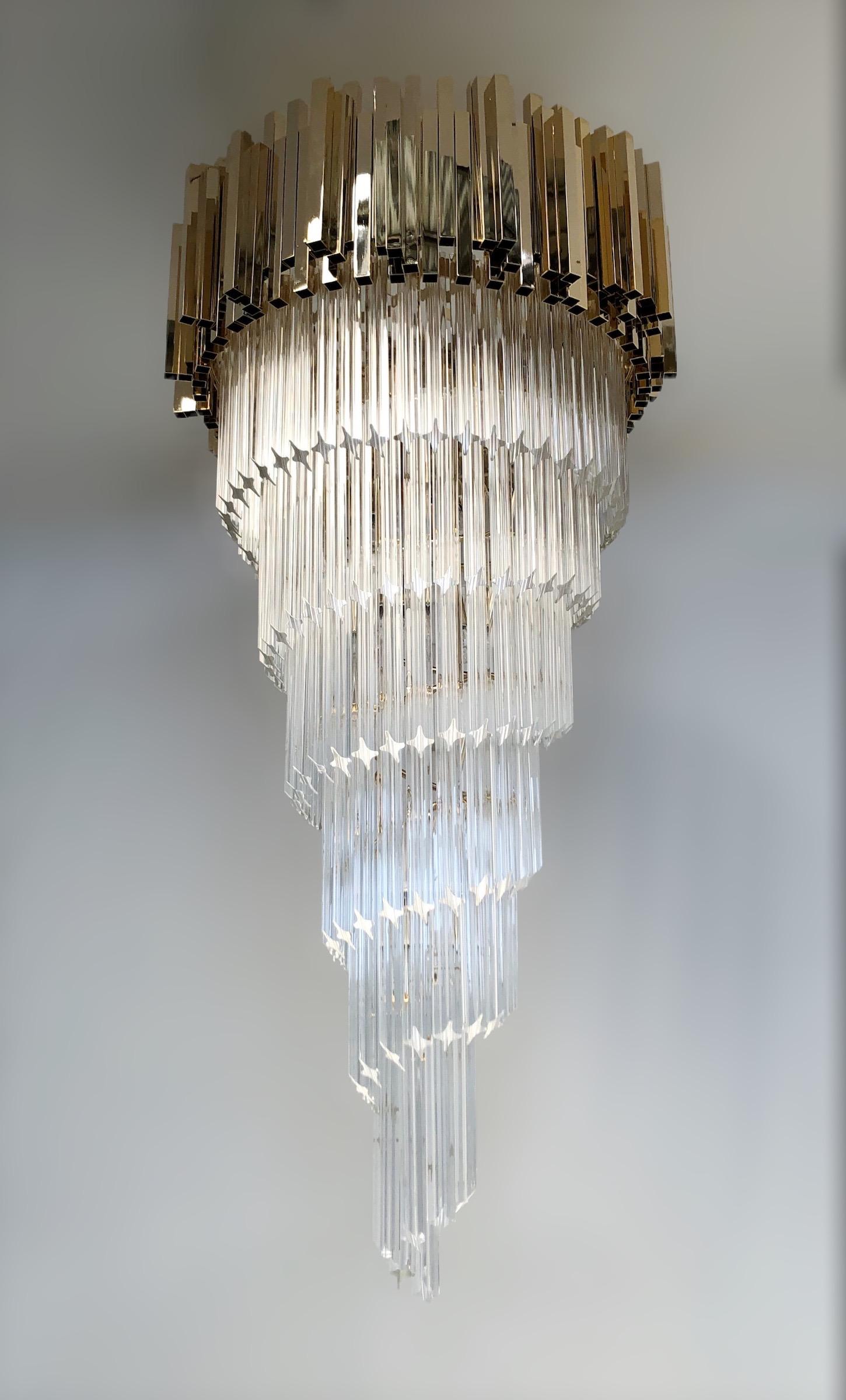 Italian spiral chandelier shown in clear Murano glasses cut into four points using Quadriedri technique with a hand crafted geometric crown on top in light gold metal finish by Fabio Ltd / Made in Italy
12 lights / E12 or E14 type / max 40W
