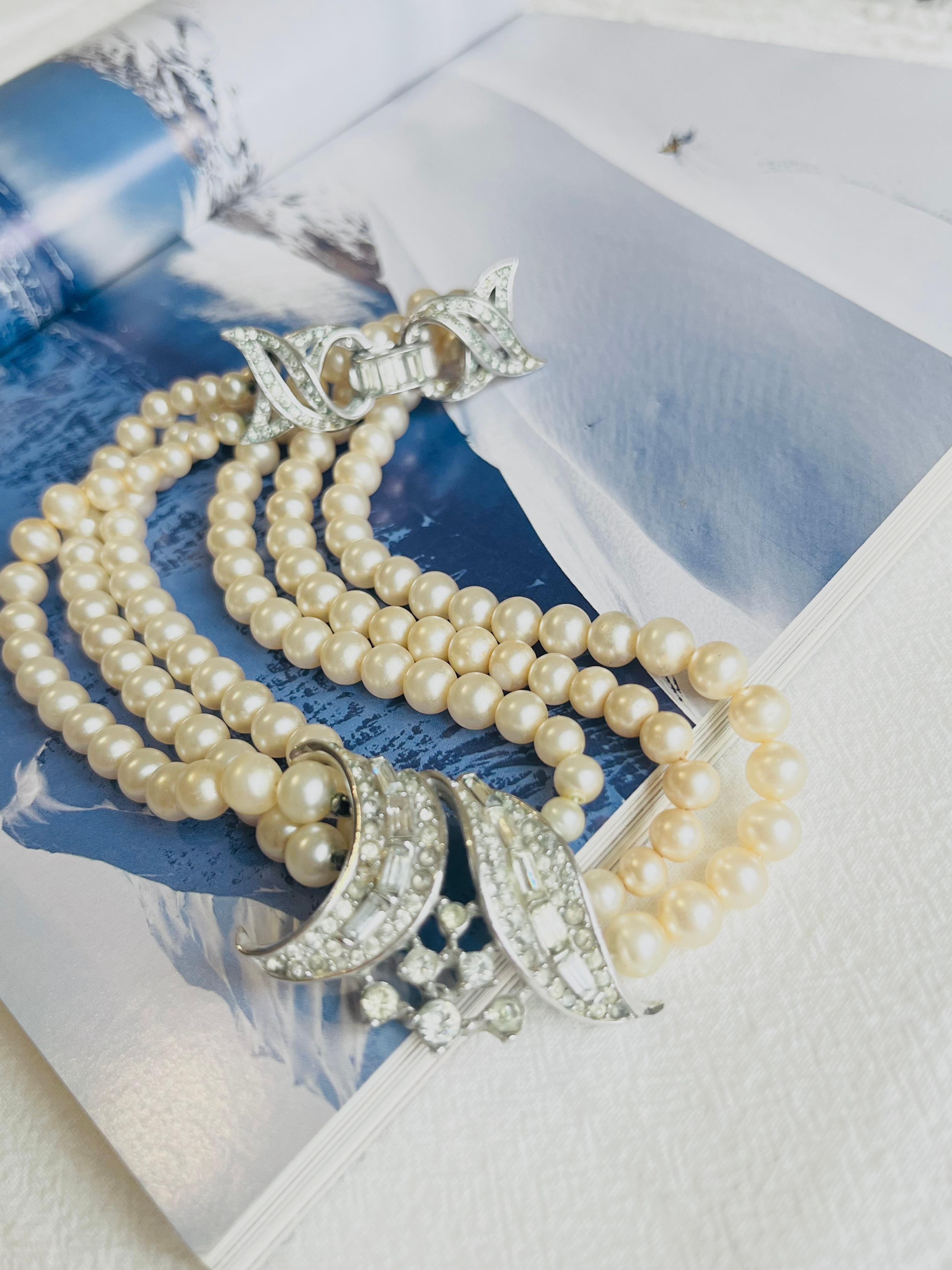 Crown Trifari 1940s Trio Strands Layer White Pearls Crystals Pendant Choker Necklace, Silver Tone

Good condition. Very light scratches or colour loss. Rare to find. 100% Genuine. 

A very beautiful necklace, signed at the back.

Material: Silver,