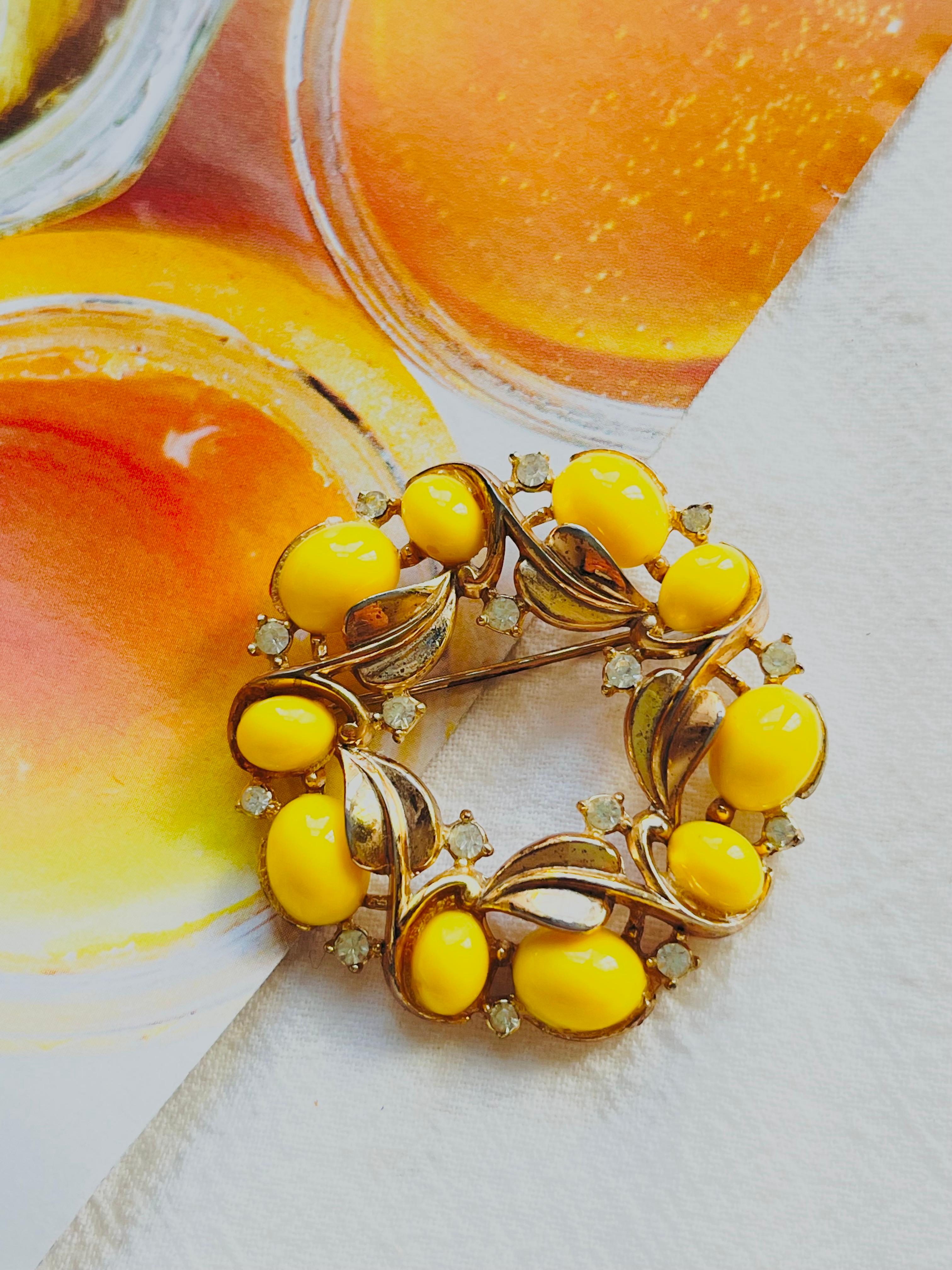 Crown Trifari 1950s Circle Yellow Cabochon Wreath Flower Leaf Crystals Brooch, Gold Tone

Good condition. Some light scratches and colour loss at back, since over 70 years. Still beautiful and good to wear. 

A very beautiful brooch, signed at the
