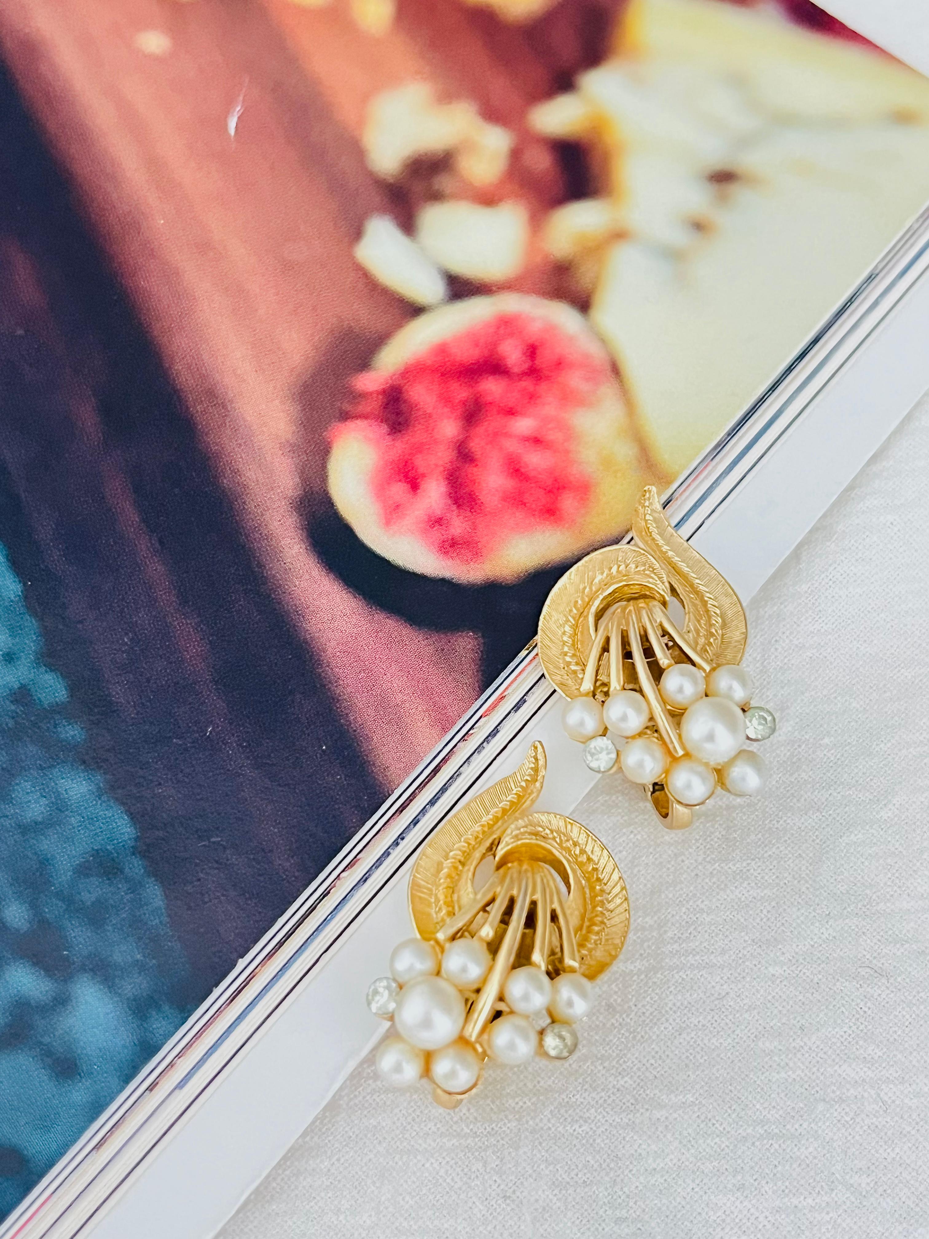 Crown Trifari 1950s White Pearls Crystals Bouquet Flower Dandelion Swirl Leaf Openwork Clip Earrings, Gold Tone

Very good condition. Light scratches or colour loss, barely noticeable. 100% genuine.

A very beautiful earrings, signed at the