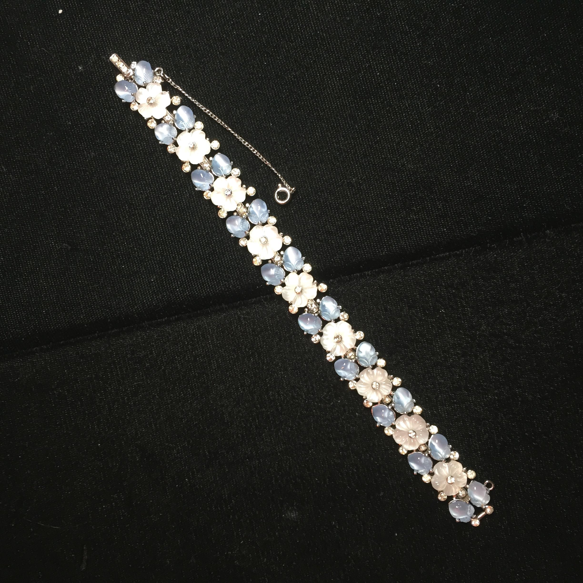Offered here is a Crown Trifari rhodium link bracelet designed by Alfred Philippe, from the 1940s. Each heavily rhodium-plated link presents an opalescent white carved glass flower centered with a tiny clear crystal and flanked by four tiny