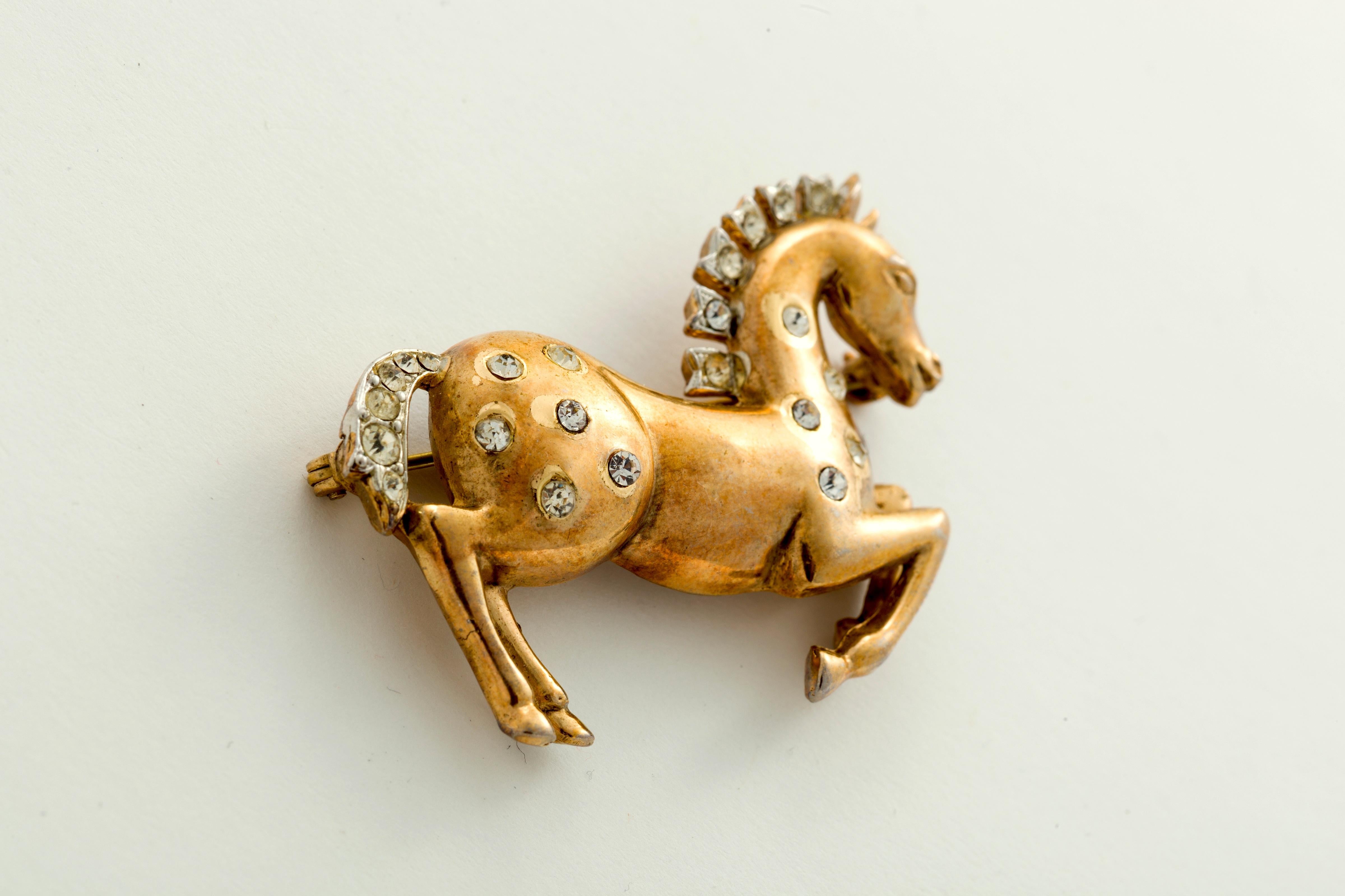 Rare is this early Crown Trifari galloping horse with rhinestones in his body and mane.  Signed on the reverse.  Actually to the eye it is much prettier with a shiny gold body and sparkling stones.  
