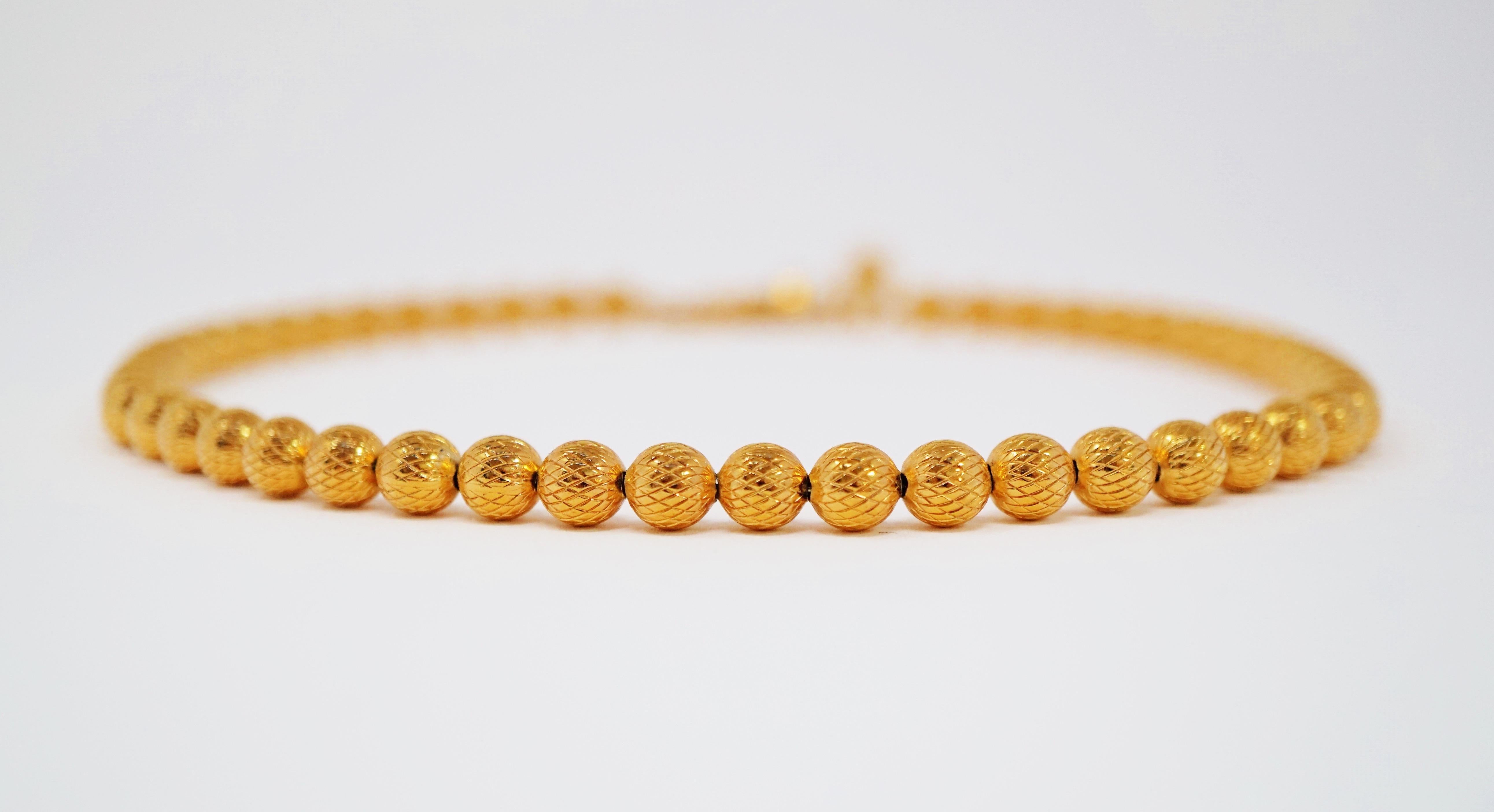 This beautiful, modern gold-tone textured bead choker was designed and manufactured by coveted jewelry brand Trifari, circa 1955. Trifari is a highly collected costume jewelry brand, noted for it's high quality of construction and intricate details.
