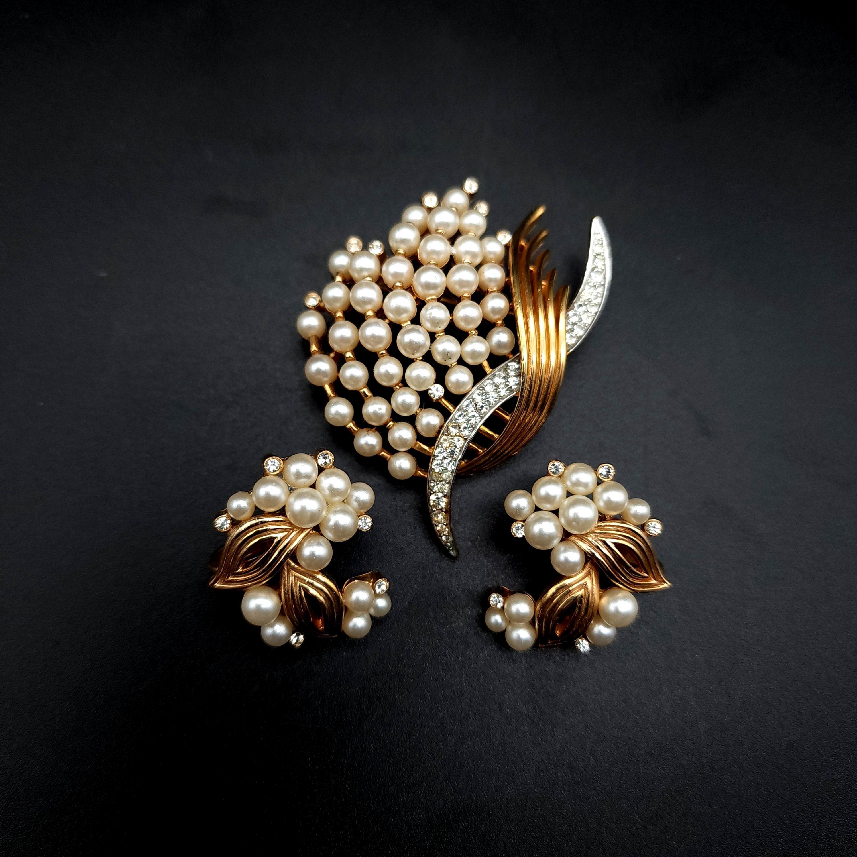 This glamorous 20th century Crown Trifari brooch and clip on earrings set.  Decorated with faux pearl & rhinestones. For a sophisticated and stylish look!

Marks / hallmarks / etc:  Crown Trifari 
Pin: 2 1/4 in
Earring: 1 in
Condition: Excellent