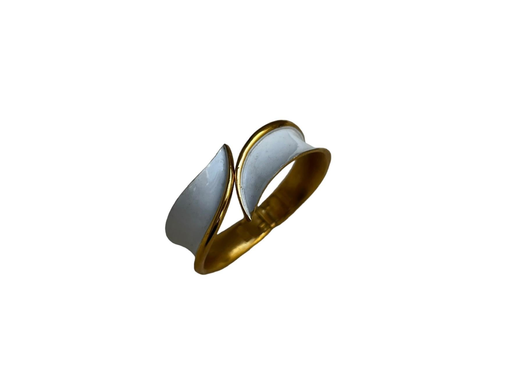 Bracciale Crown Trifari del 1950.
Smalto bianco con eleganti bordi dorati.
Il lato interno è altrettanto splendido, in oro spazzolato.
Un bellissimo design curvilineo
Questo bracciale è ideale per un polso piccolo; il mio polso è 5 3/4 e il