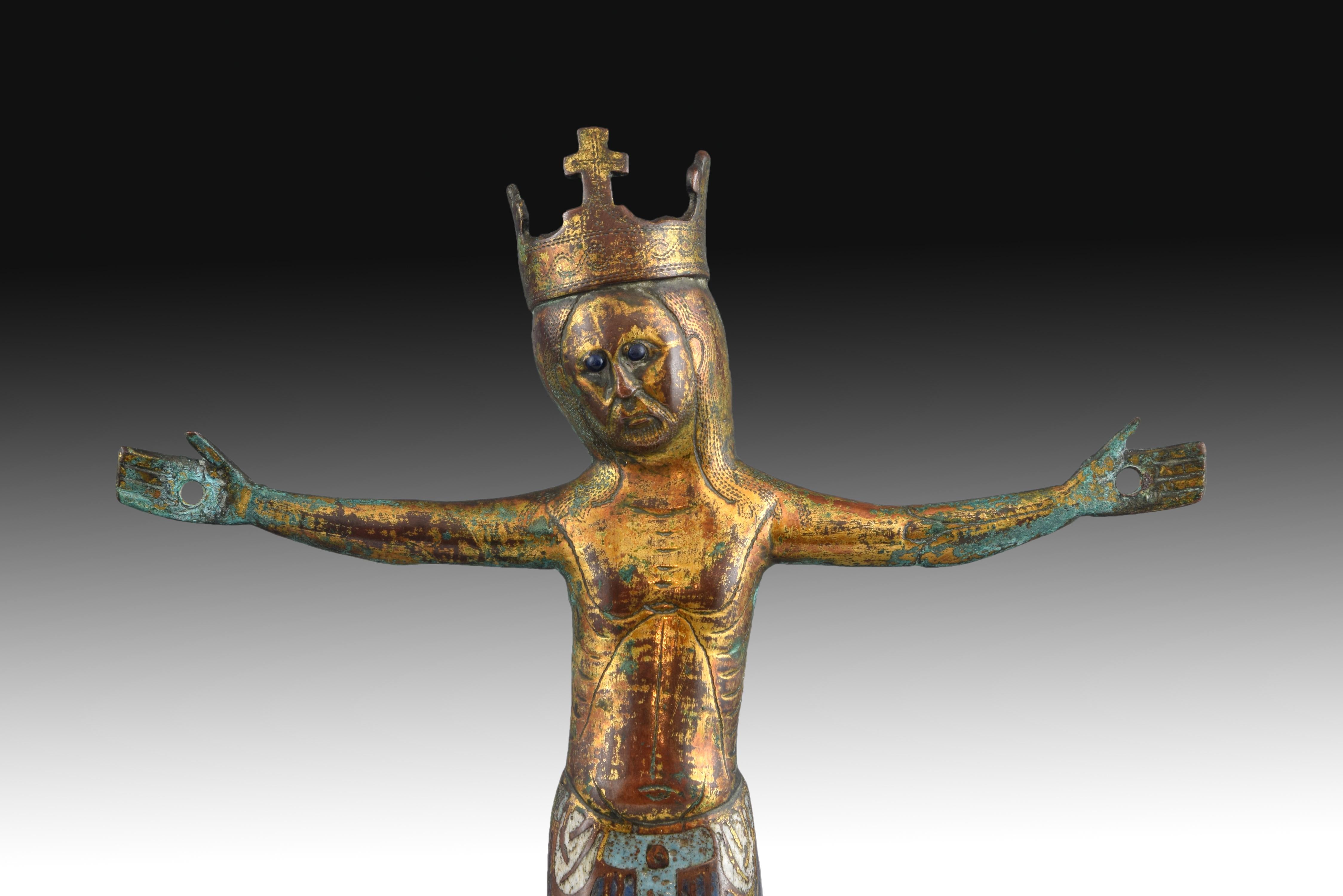 Gilt copper, enamel, jet (Stone).
Metal figure of Christ crucified with four nails, decorated in blue enamels, simplified anatomy, open eyes (jet) and open crown topped by a cross, which is decorated (like the hair) with bands of small engraved dots