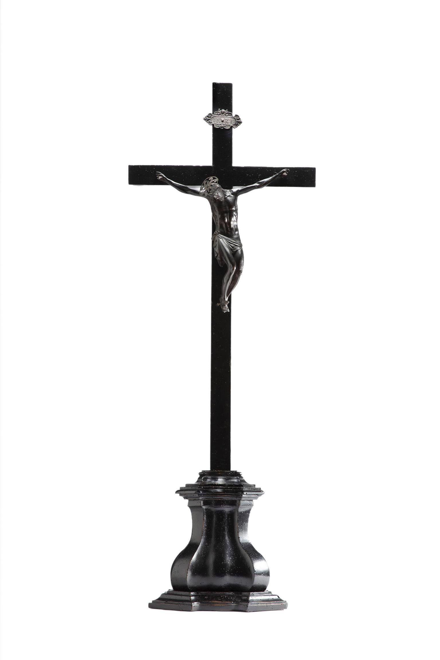 Crucifix
Lombardy, mid-17th century
Bronze, iron, and wood
Sculpture: 33 cm height x 35 cm width x 10 cm depth at the knees;
Cross: 42.12 in height x 19.68 in width (107 cm x 50);
Base: 13.38 in height x 13.58 in width x 7.08 in depth. (34 cm x 34.5