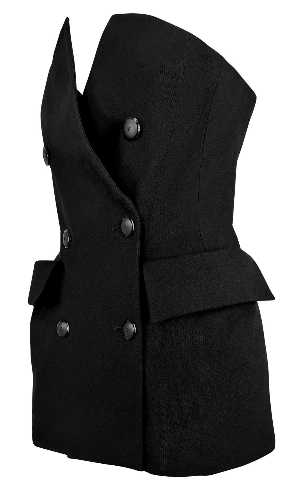 Presenting a striking black mini dress from Yves Saint Laurent Rive Gauche’s Cruise 1989 collection. This tailored piece is designed with a structured double-breasted front, and exaggerated flap pockets. The sleek, silhouette is nipped at the waist